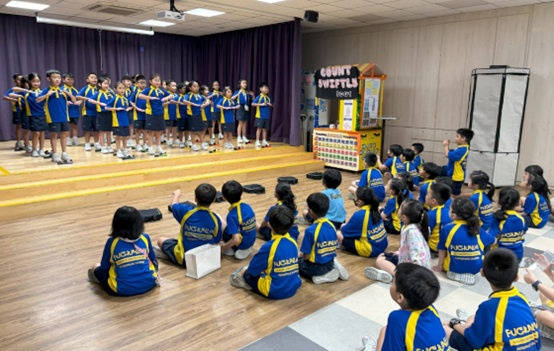 Students participating in a group performance while their peers watch and support them.