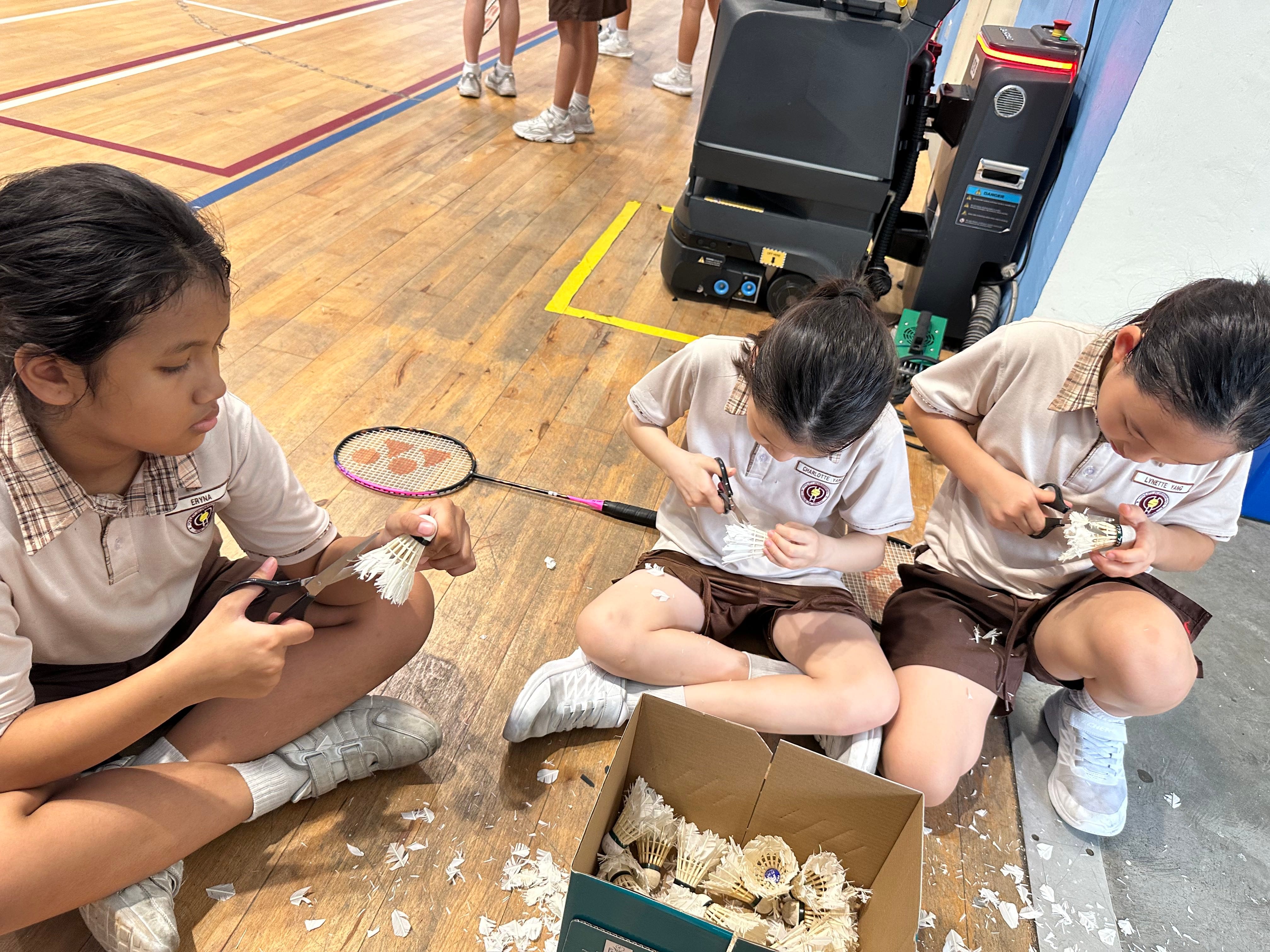 Students collecting and trimming used shuttlecocks as part of their VIA project