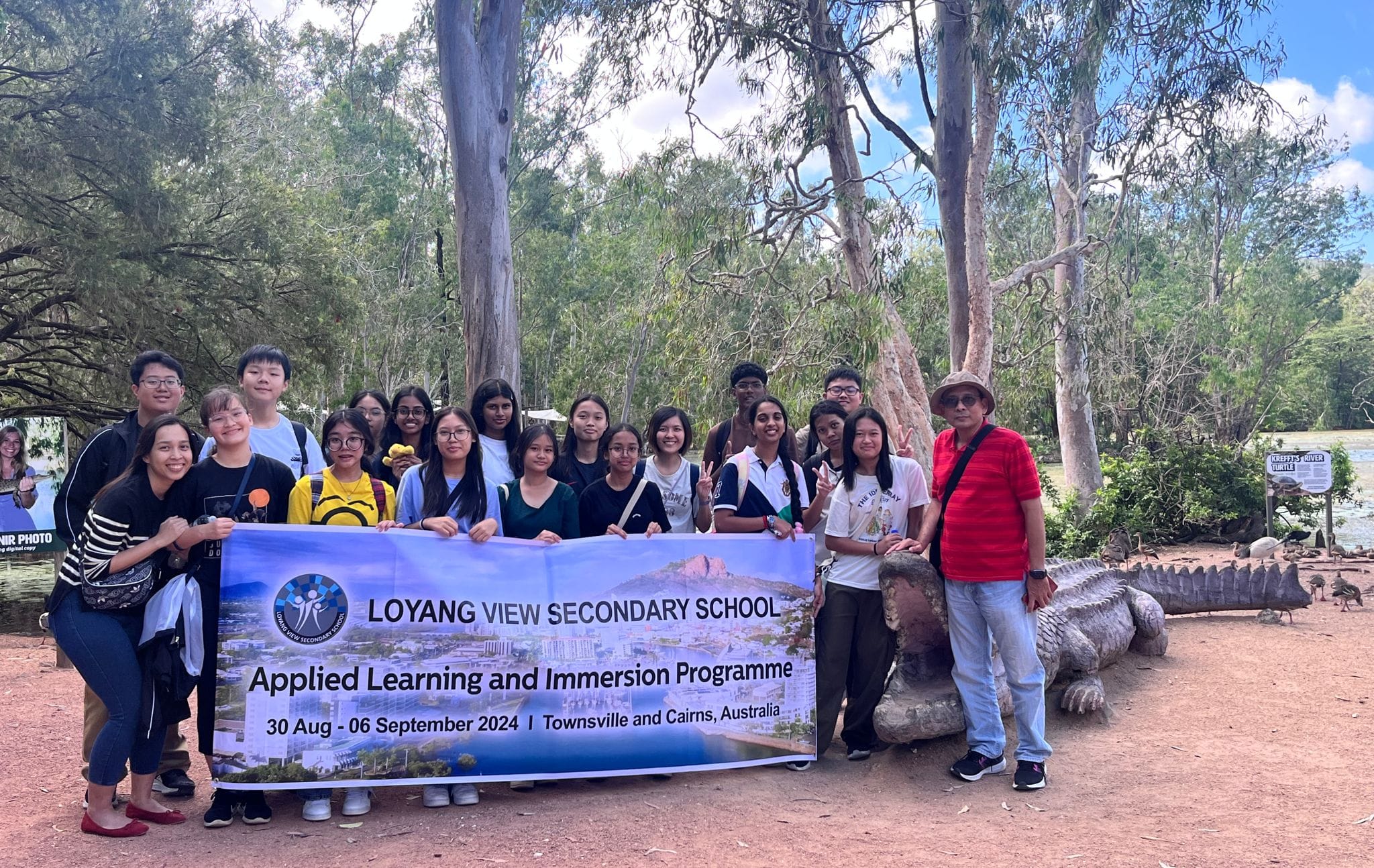 Group of students and adults holding a Loyang View Secondary School immersion programme banner in Australia, 2024.