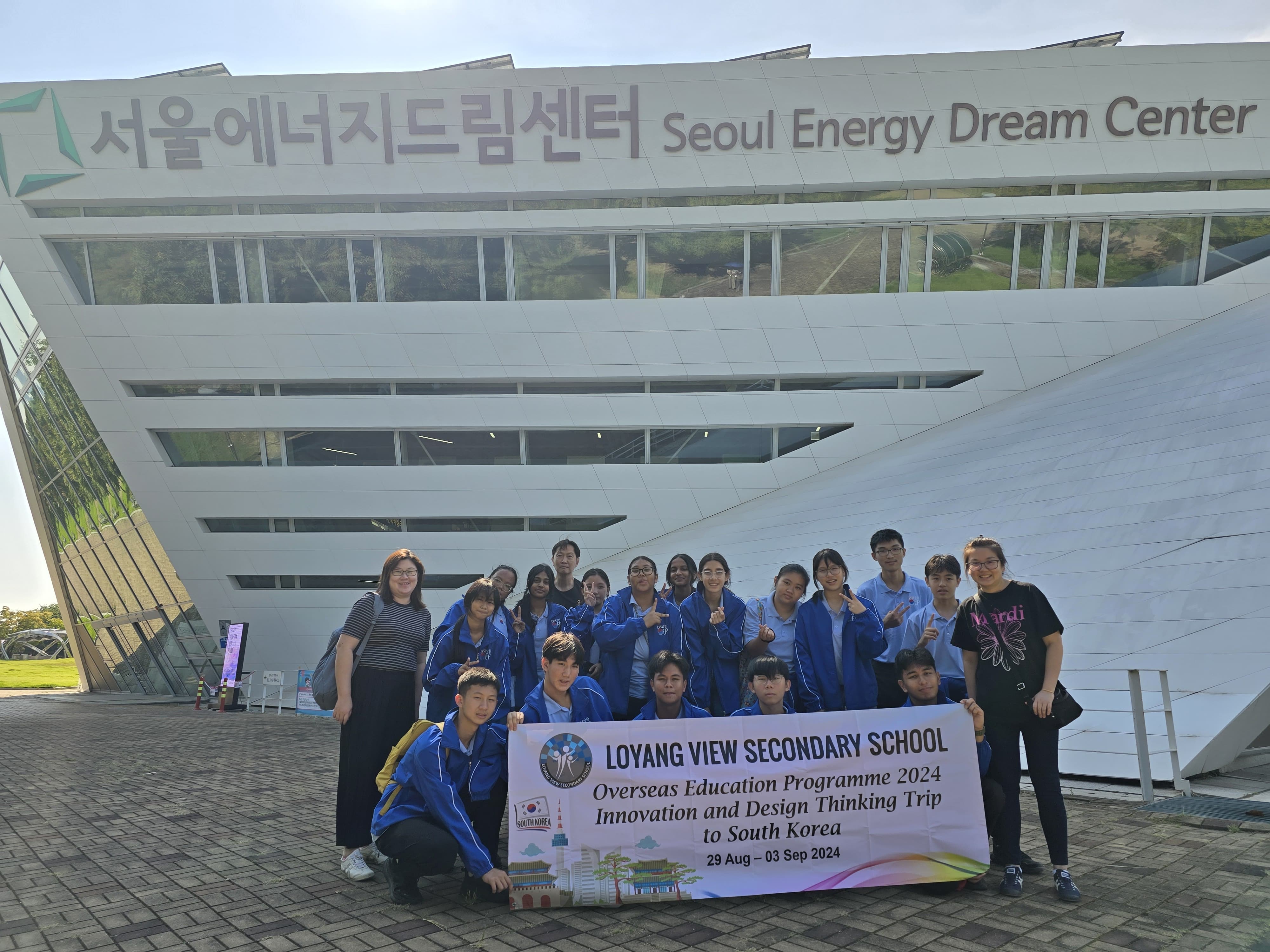 Students from Loyang View Secondary School pose with a banner in front of the Seoul Energy Dream Center building.