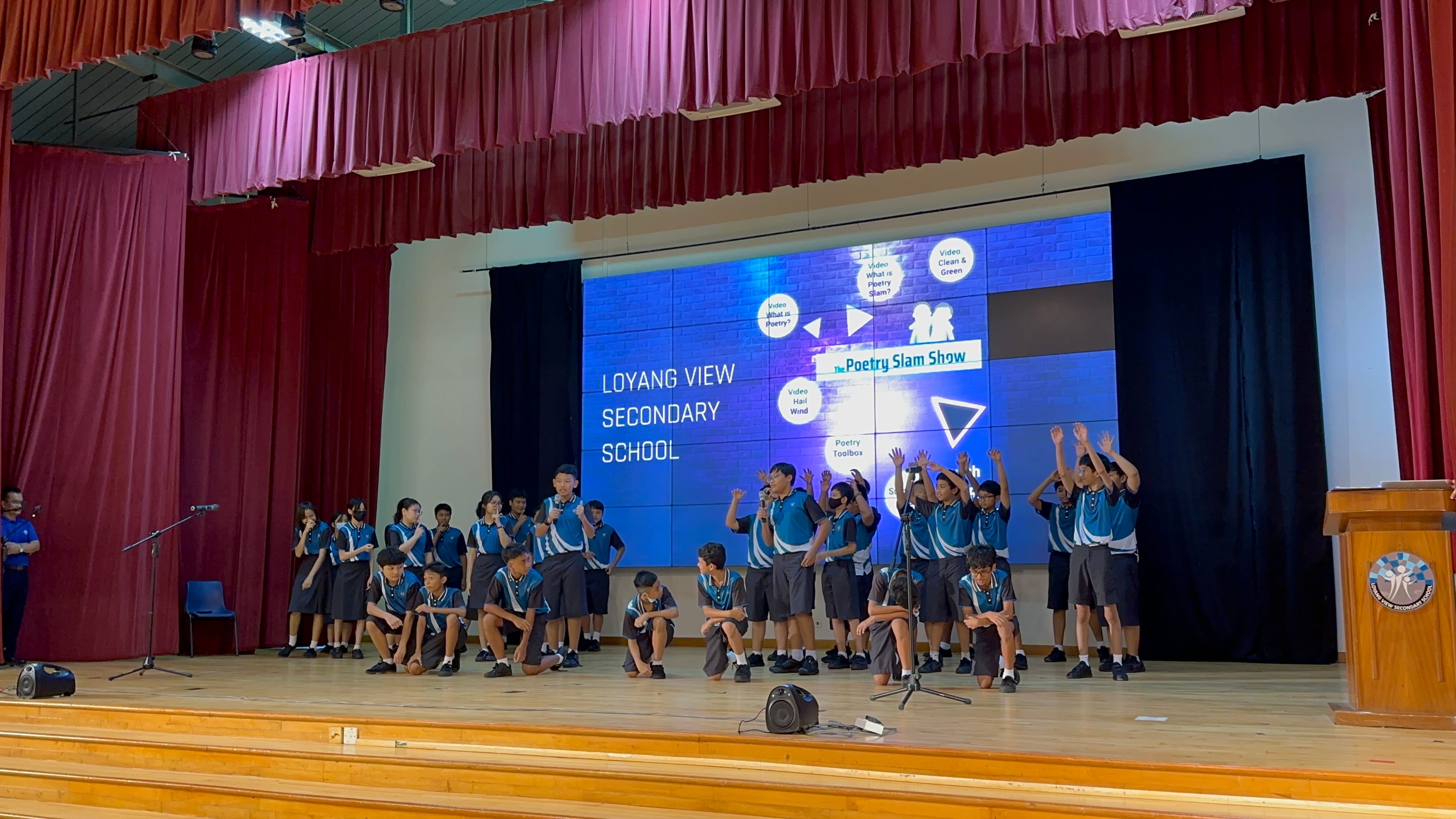 Students in blue uniforms perform on stage at Loyang View Secondary School's Poetry Slam Show.