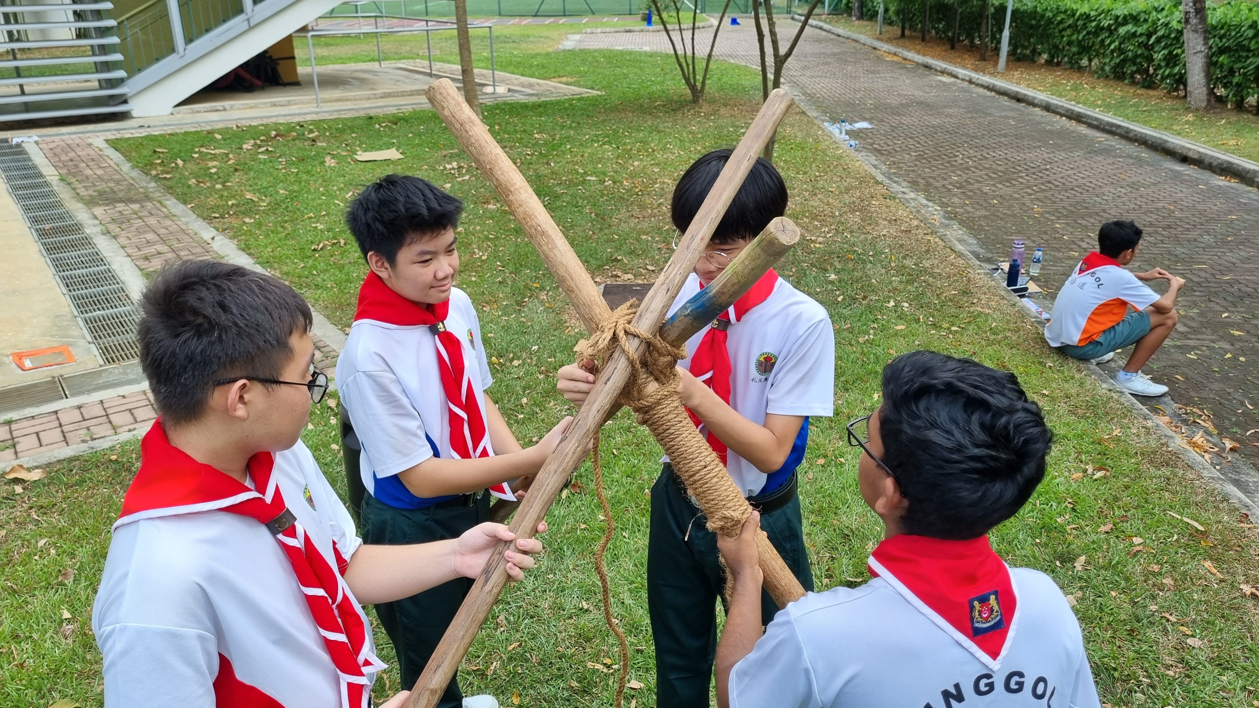 PSS Scouts practising tripod building with bamboo poles during a pioneering activity