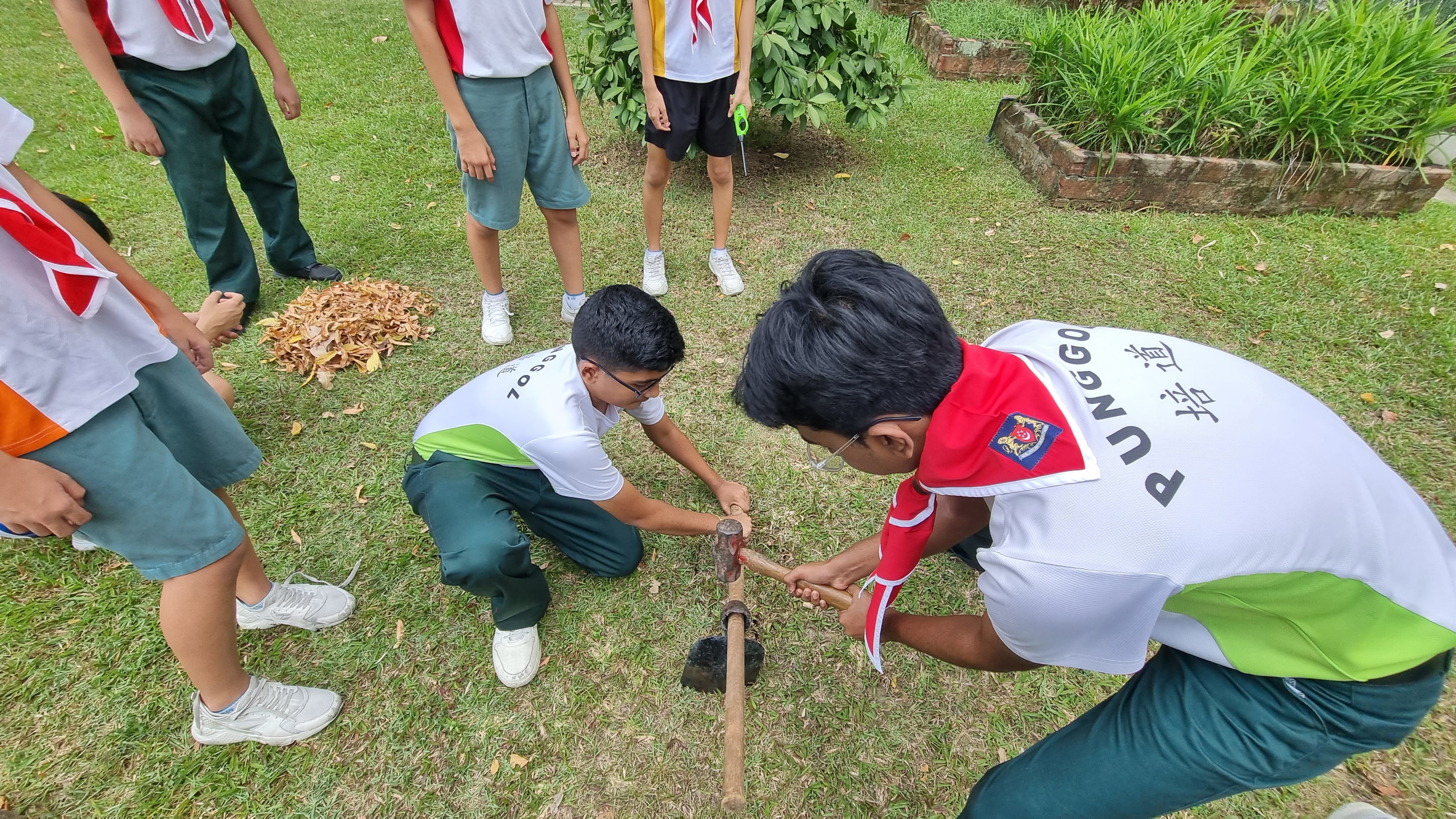 PSS Scouts digging a fire pit during outdoor camp or survival skills training