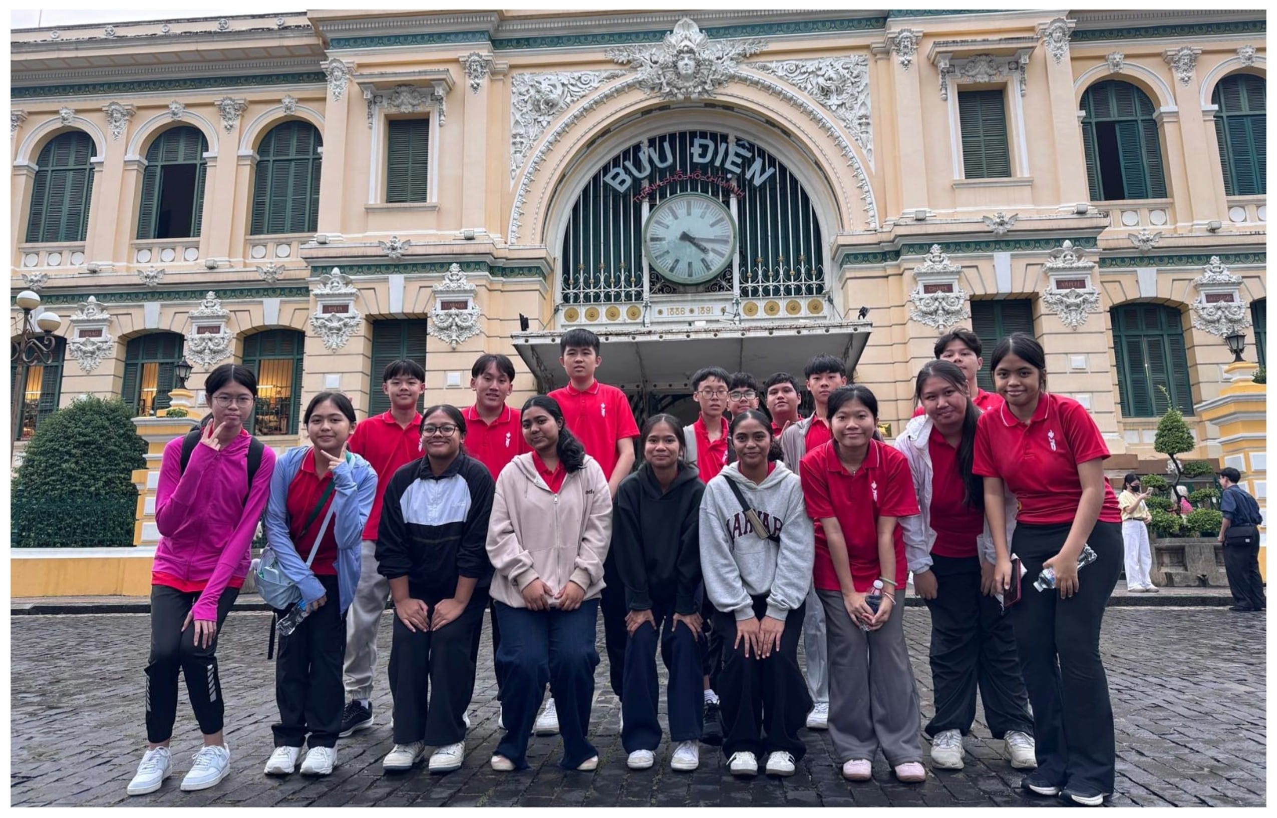 A group of young people pose in front of the Buu Dien post office building in Ho Chi Minh City, Vietnam.