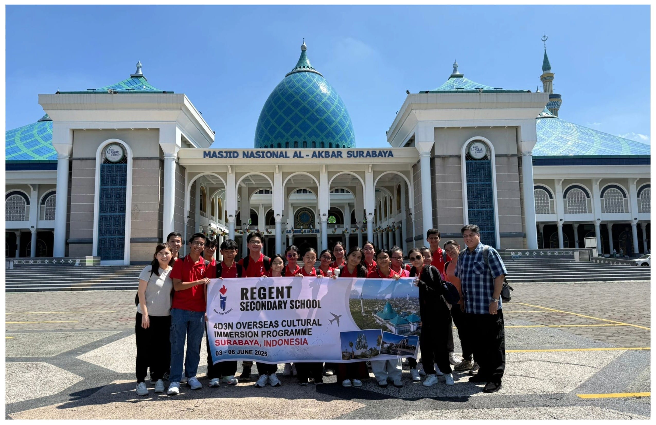 A group of students in red shirts hold a Regent Secondary School banner in front of Masjid Nasional Al-Akbar Surabaya.