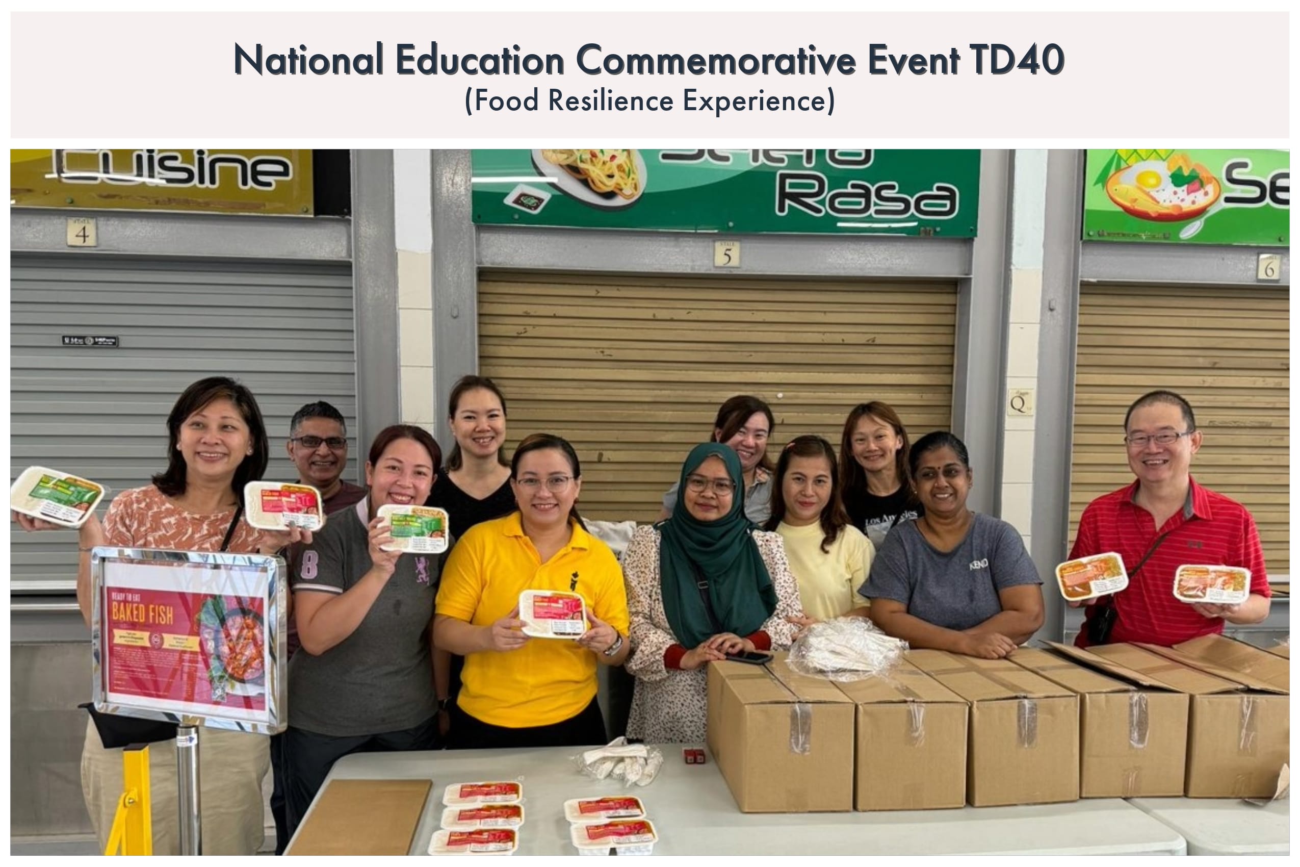 A group of people hold food trays and stand near cardboard boxes at a Food Resilience Experience event.