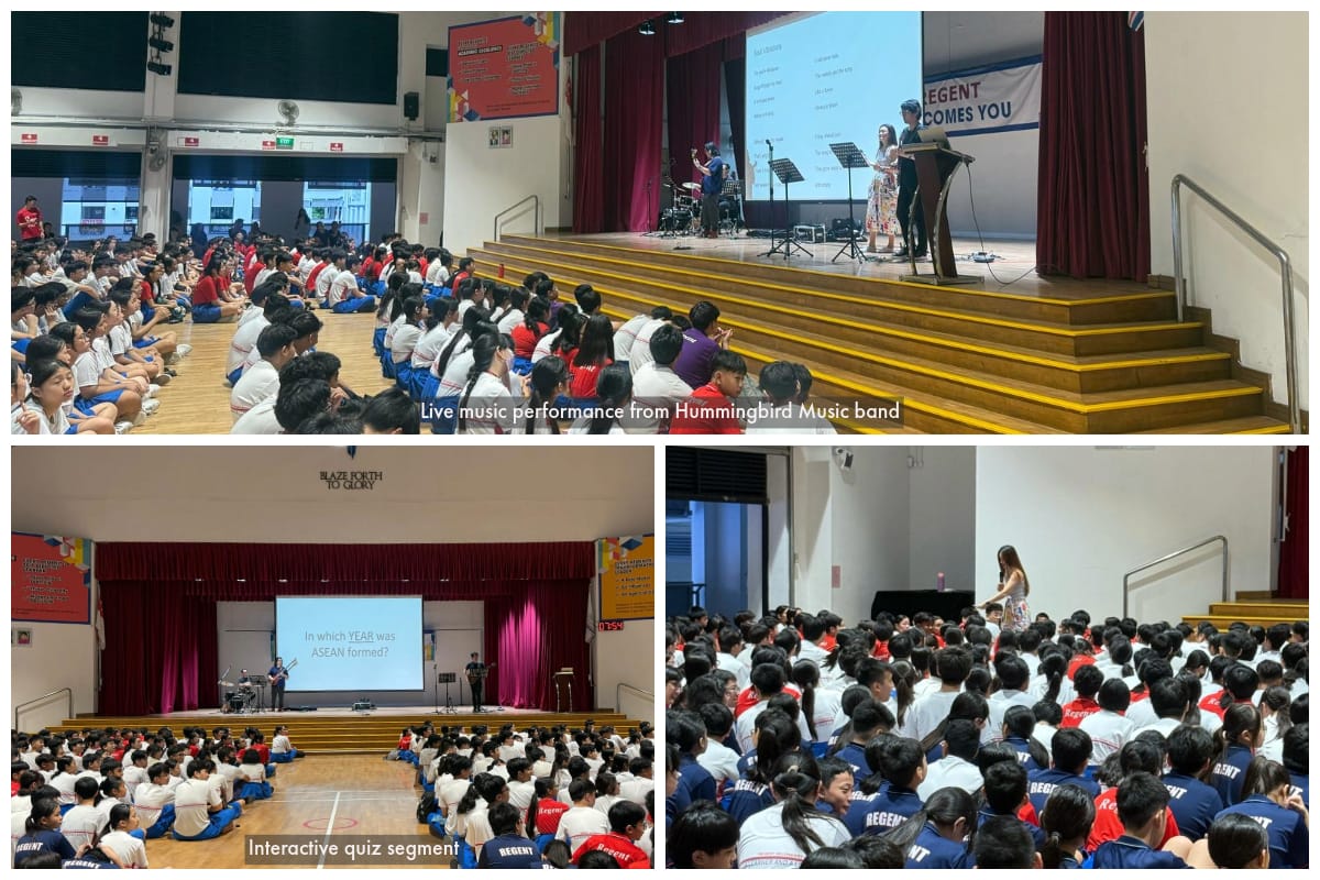 Students in school uniforms sit on a hall floor watching a stage presentation and live music performance at Regent school.