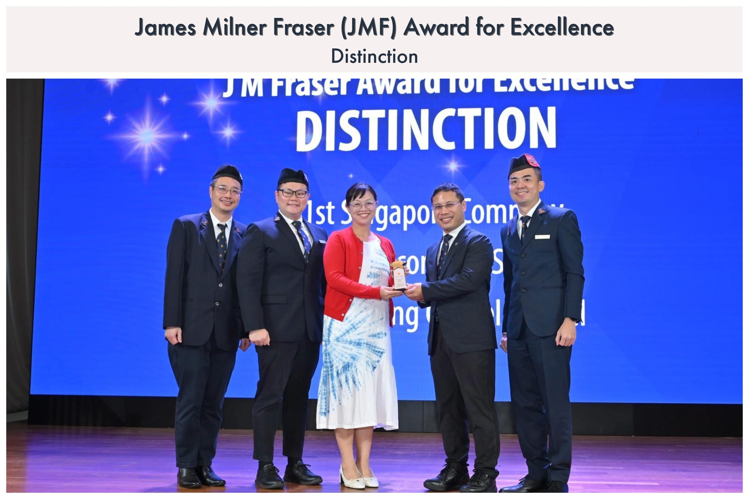 Five people pose on stage holding a trophy at the JM Fraser Award for Excellence Distinction ceremony.