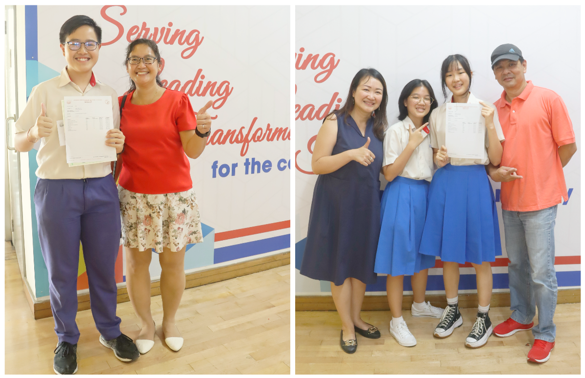 Two groups of smiling people holding documents stand in front of a wall with text reading Serving, Leading, Transforming.