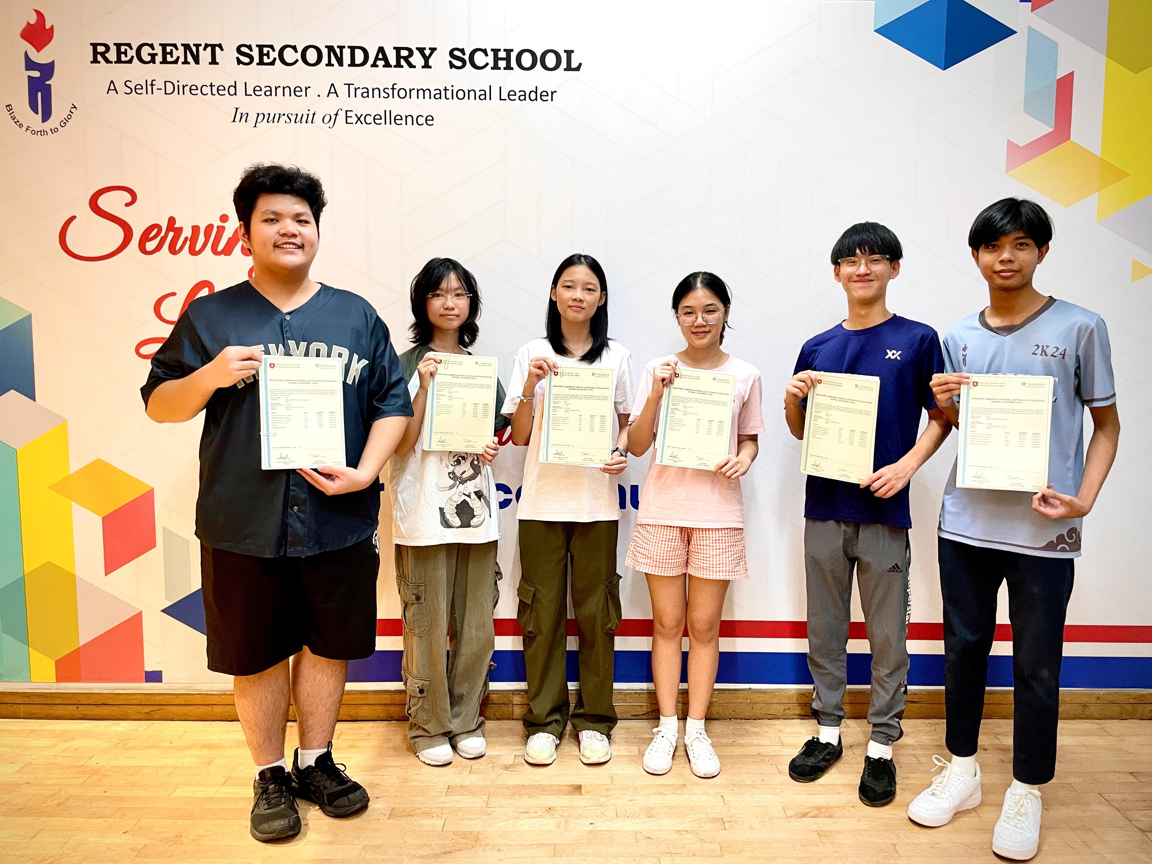 Six students stand in front of a Regent Secondary School banner, each holding up official certificates or result sheets.