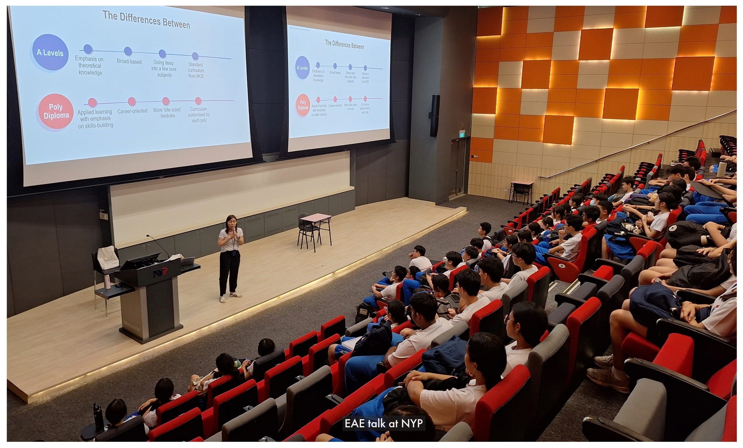 A speaker presents to students in a lecture hall at NYP, with two screens showing differences between A Levels and Poly Diploma.