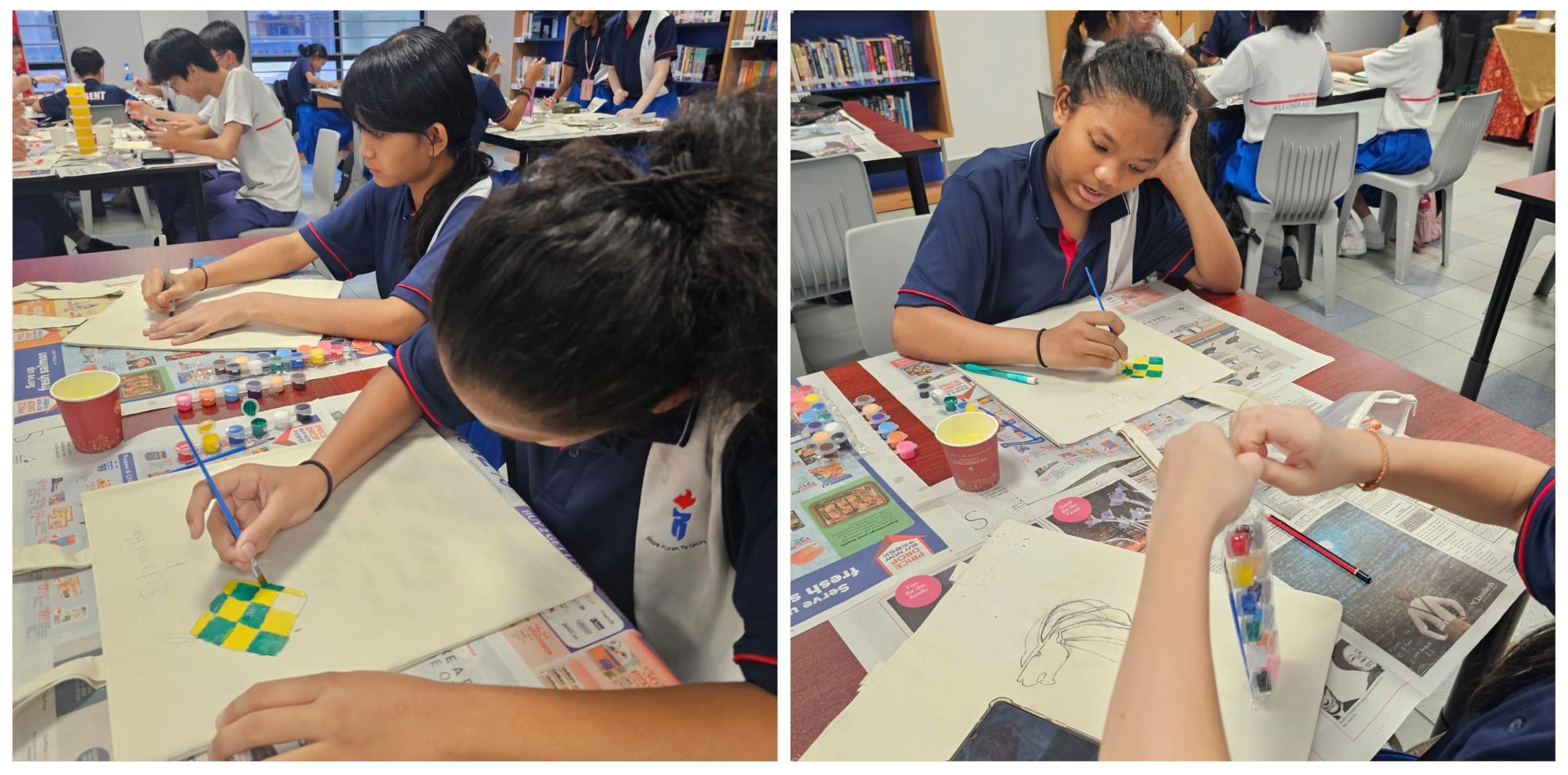 Students in blue uniforms painting on paper with small paint pots on newspaper-covered tables in a library.