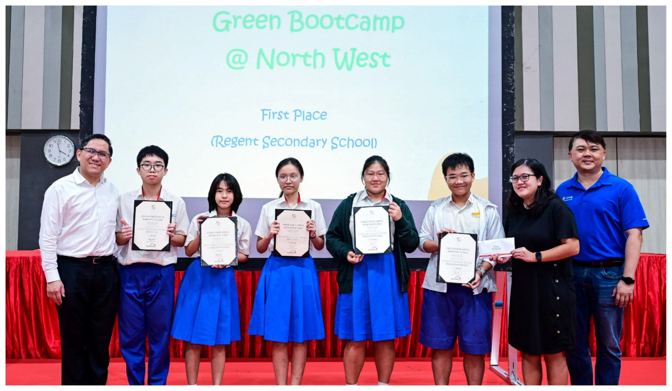Students and adults pose holding certificates at a Green Bootcamp North West First Place award ceremony.