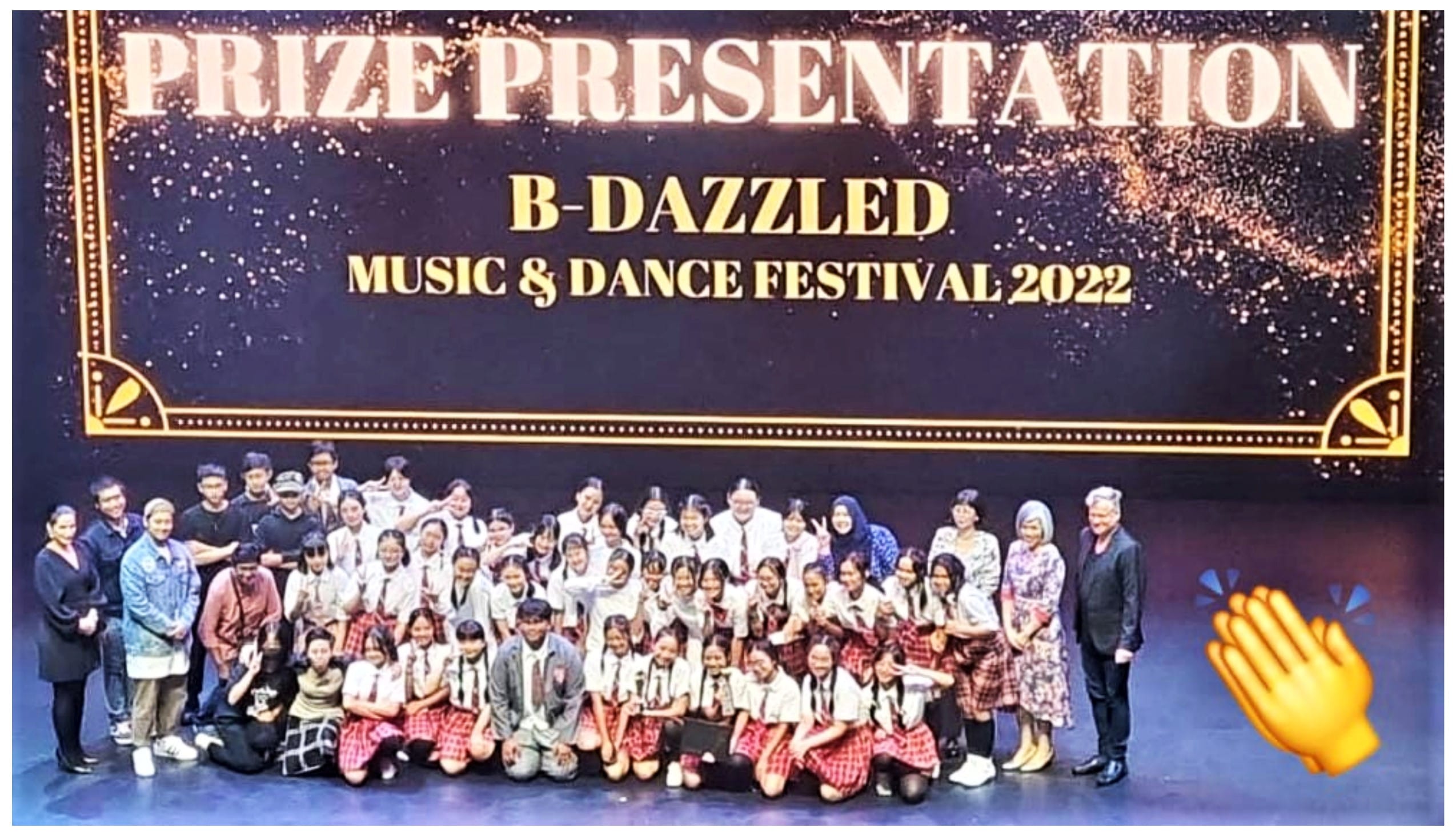 Large group of students and adults posing on stage at B-Dazzled Music and Dance Festival 2022 prize presentation.