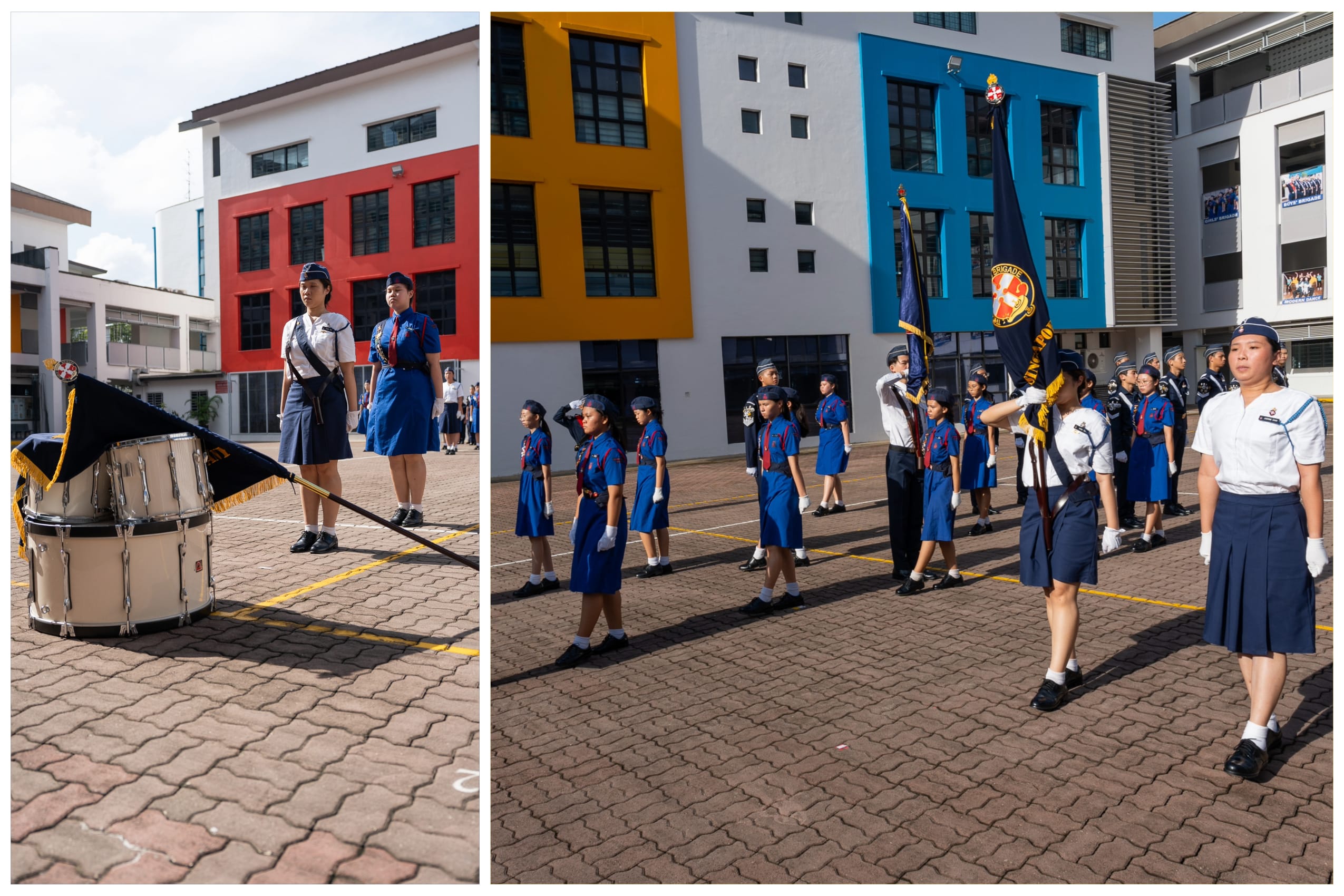 Students in uniform march in formation with flags in a school courtyard; a snare drum sits in foreground.