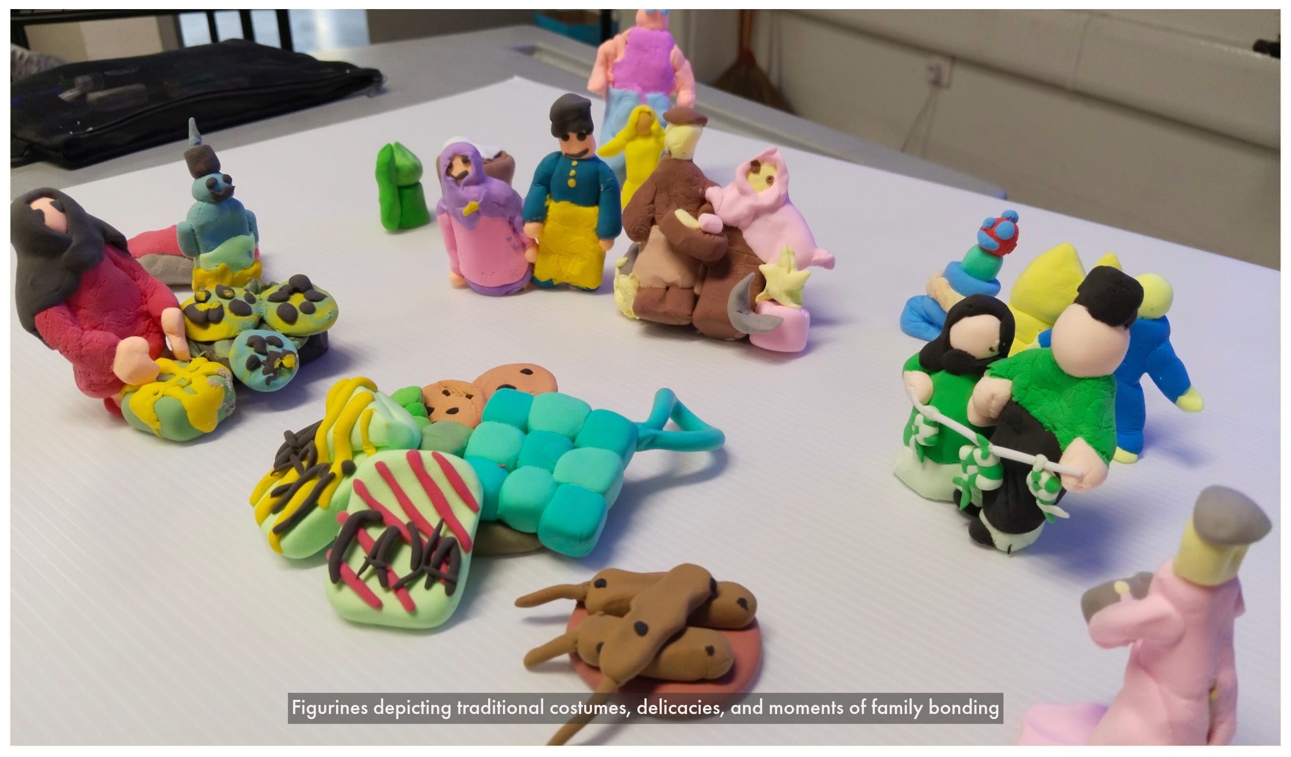 Colorful clay figurines of people, animals, and objects arranged on a white table.