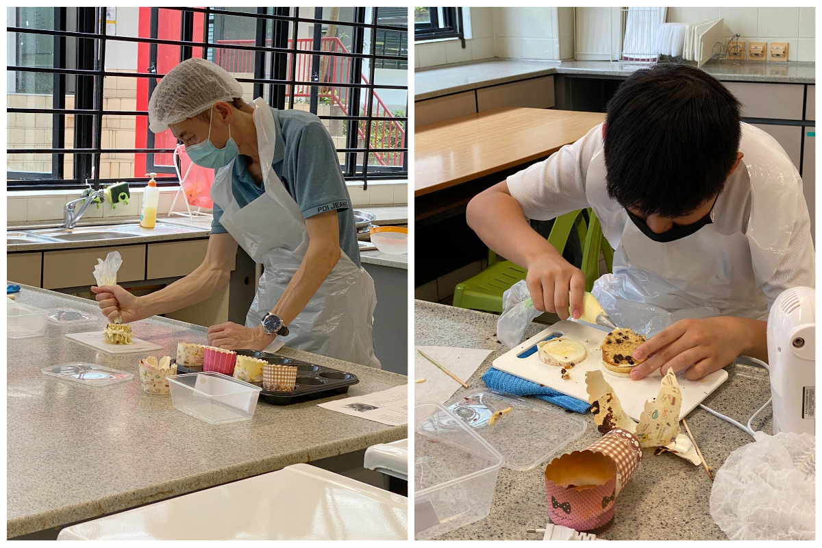 Two masked people in aprons decorating cupcakes in a kitchen, one using a piping bag and the other cutting a baked item.