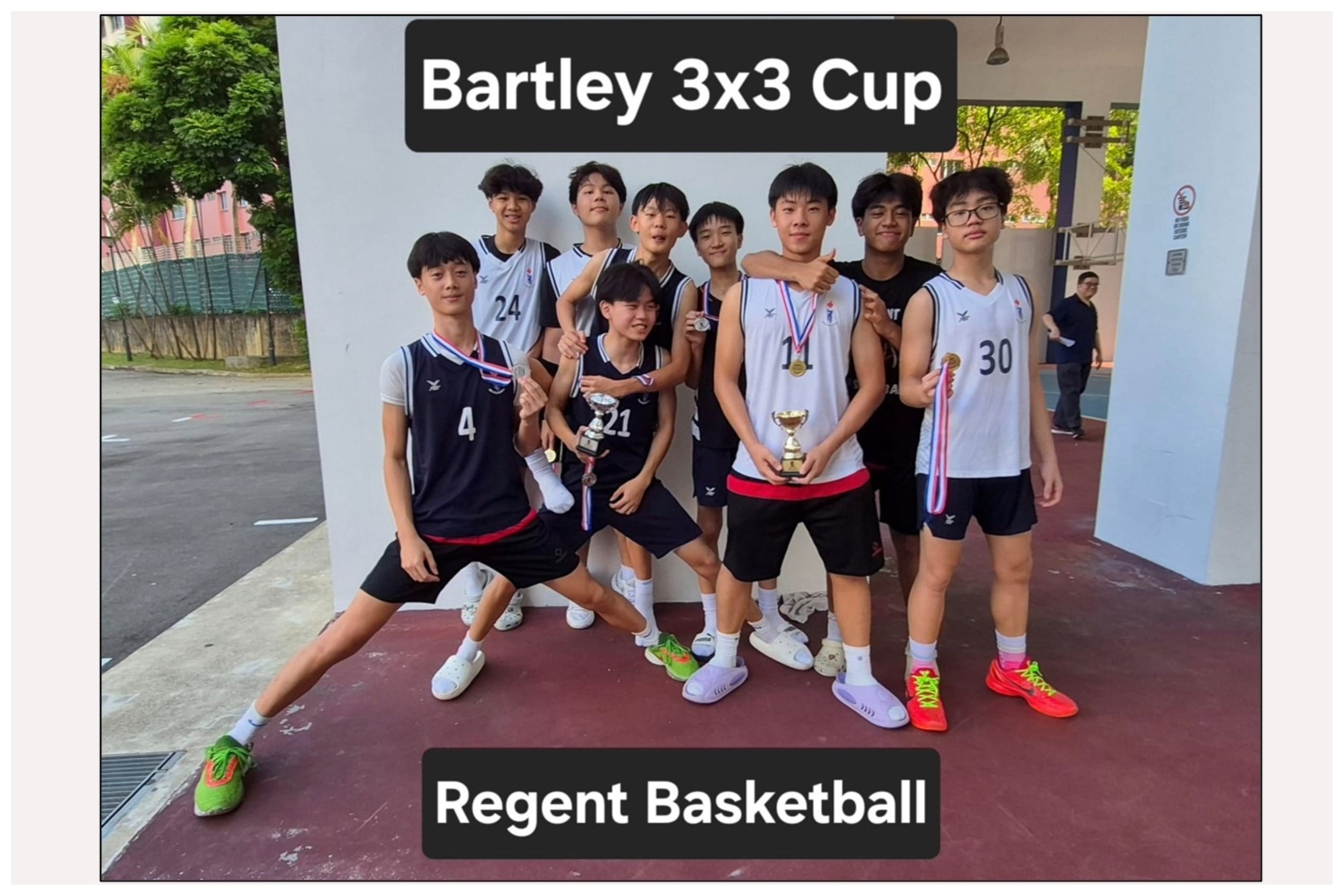 Nine young male basketball players in jerseys pose with trophies and medals at the Bartley 3x3 Cup for Regent Basketball.