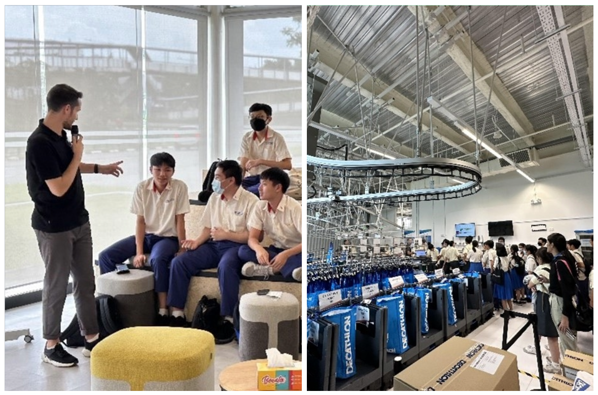 A man speaks to students seated on a sofa, beside students touring a Decathlon store with blue bags on display.