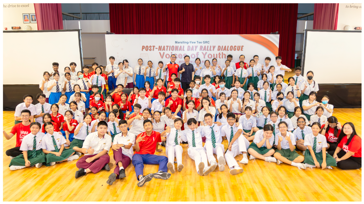 Large group of students in school uniforms posing for a photo at a Post-National Day Rally Dialogue event.