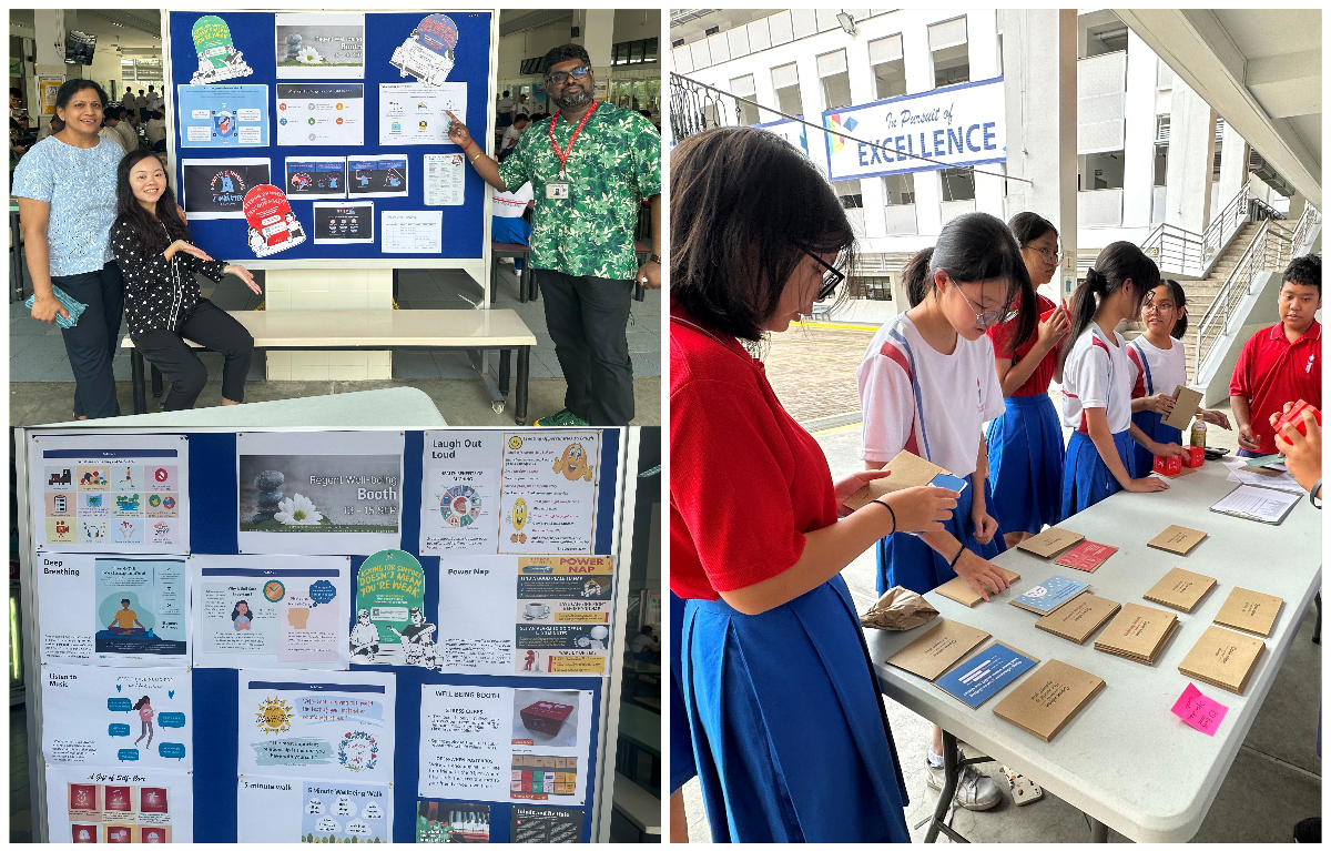 Students and teachers at a school wellness booth with informational poster boards and small notebooks on a table.