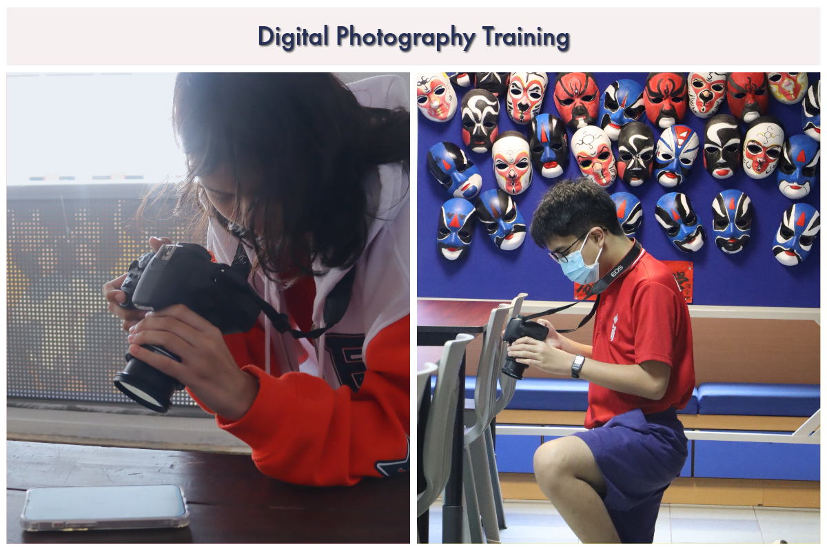 Two students holding DSLR cameras during Digital Photography Training, one near a wall of colorful Chinese opera masks.