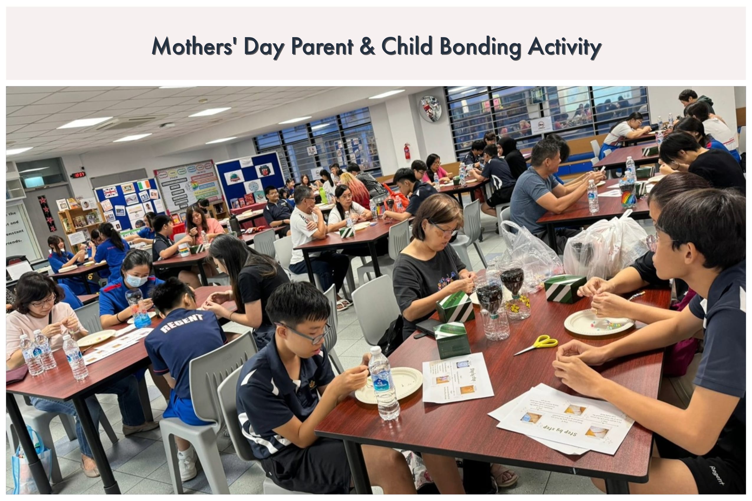 Parents and children sit at tables in a school hall doing a craft activity for Mothers' Day.