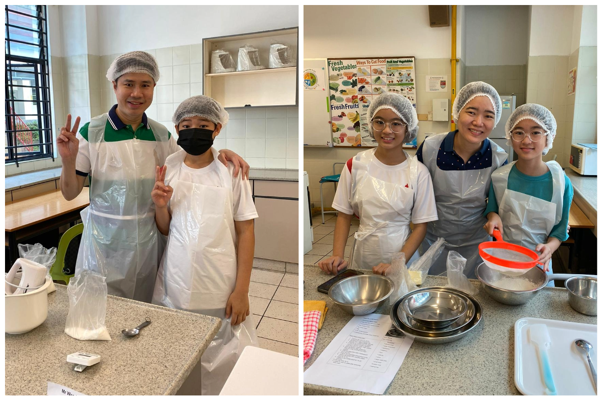 Five people in hairnets and aprons pose in a school kitchen with mixing bowls and ingredients on the counter.