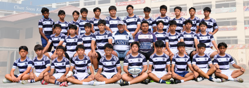 Youth rugby team in navy and white striped jerseys posing in three rows with coaches and a Gilbert rugby ball.