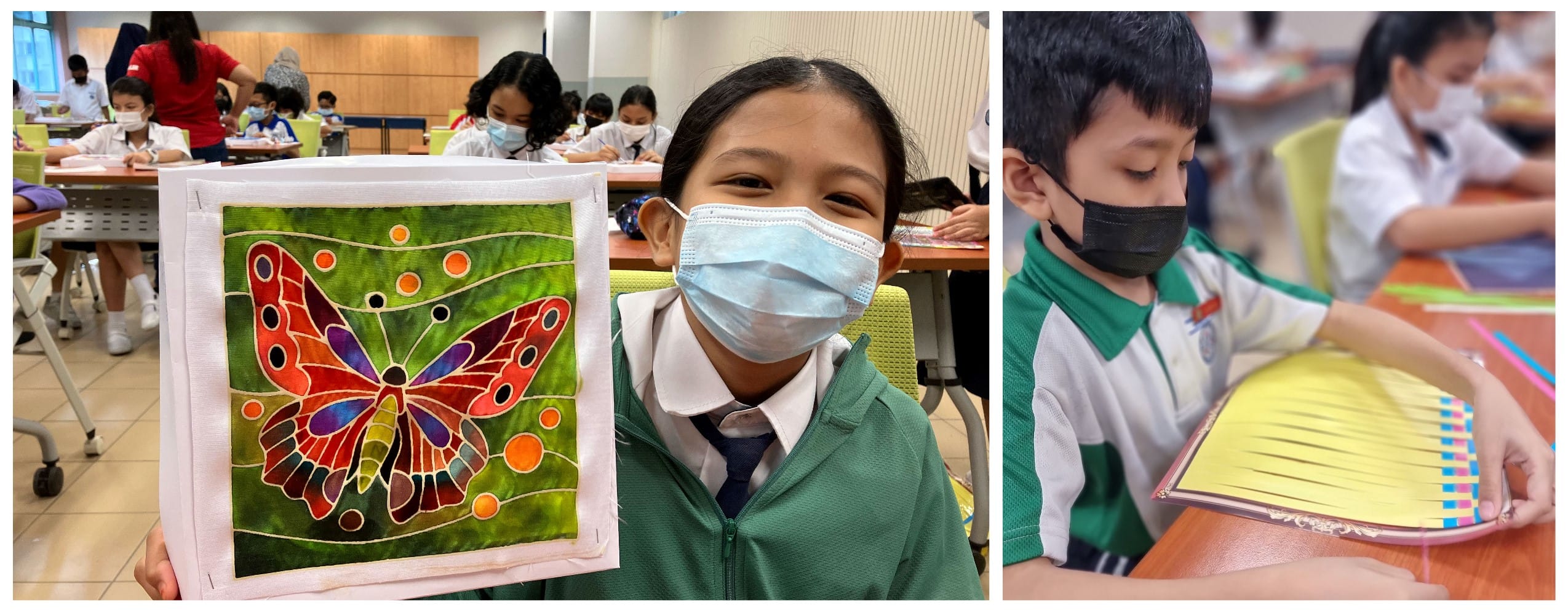 Two masked students in a classroom; one holds a colorful butterfly fabric artwork, another works on a craft project.