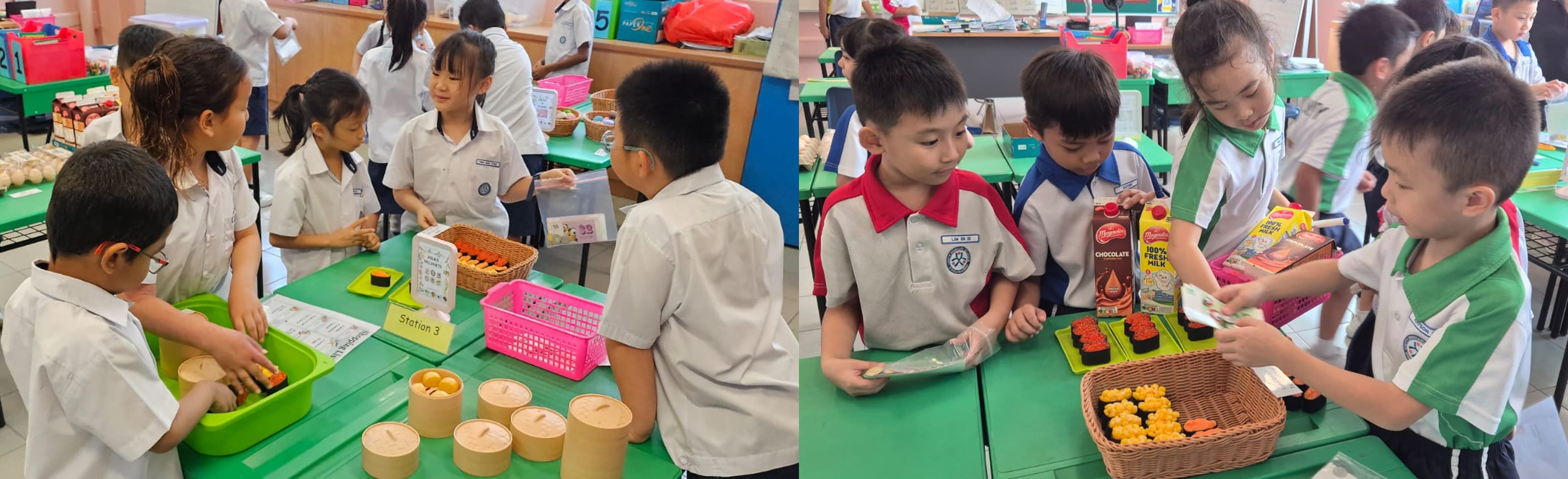 Young students in school uniforms gather around green tables with food items, baskets, and milk cartons during a classroom activity.