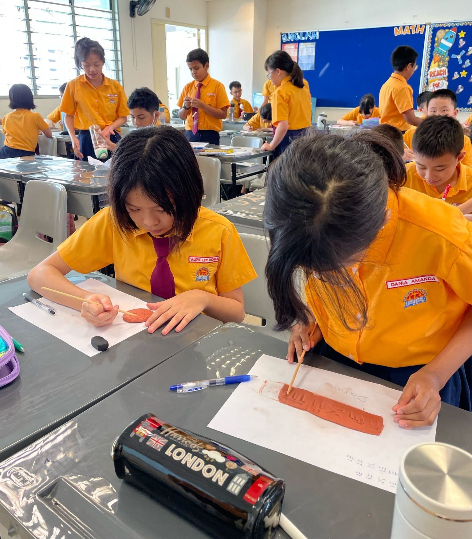 Students work on clay art projects in the classroom.