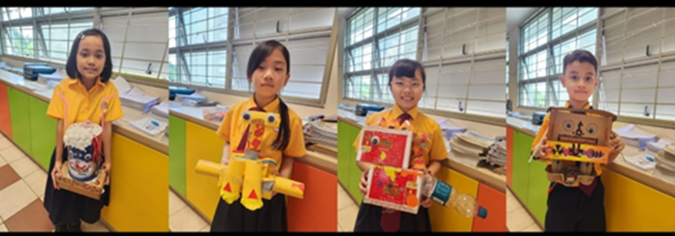 Four students each hold a handmade craft project.