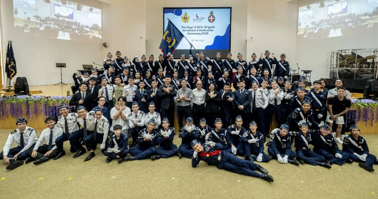 Large group in navy uniforms pose at the Boys' and Girls' Brigade Enrolment and Dedication Ceremony 2025.
