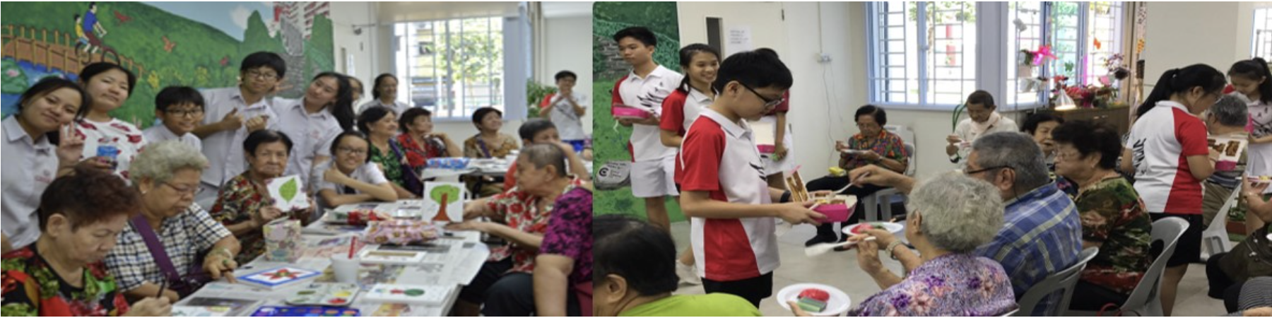 Students in uniforms interact with elderly people at tables during a community service activity indoors.