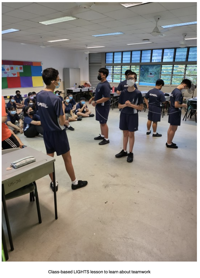 Our students stand in a circle holding a rope in a classroom activity.