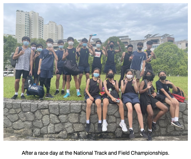 A group of students posing outdoors after a track and field race day.
