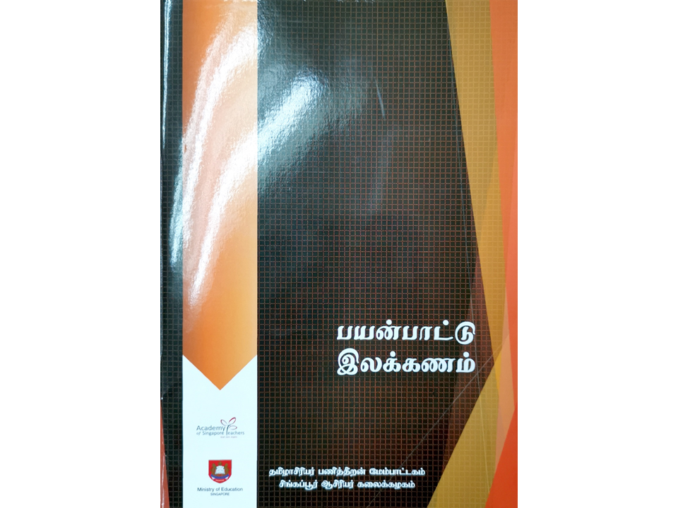 A dark book cover with Tamil script text, orange geometric design, and Singapore Ministry of Education branding.