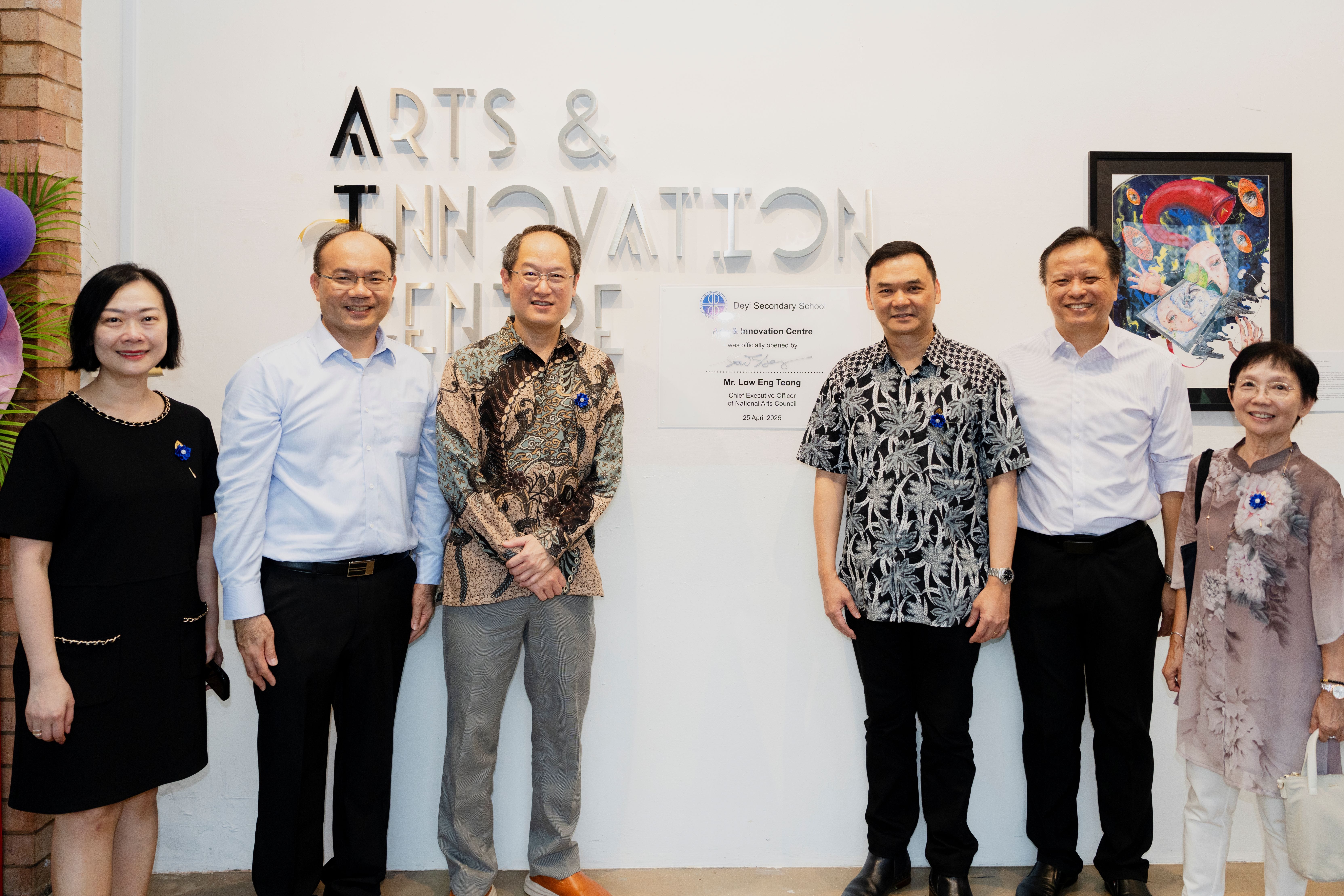 Six people pose in front of an Arts and Innovation Centre sign at Deyi Secondary School opening ceremony.