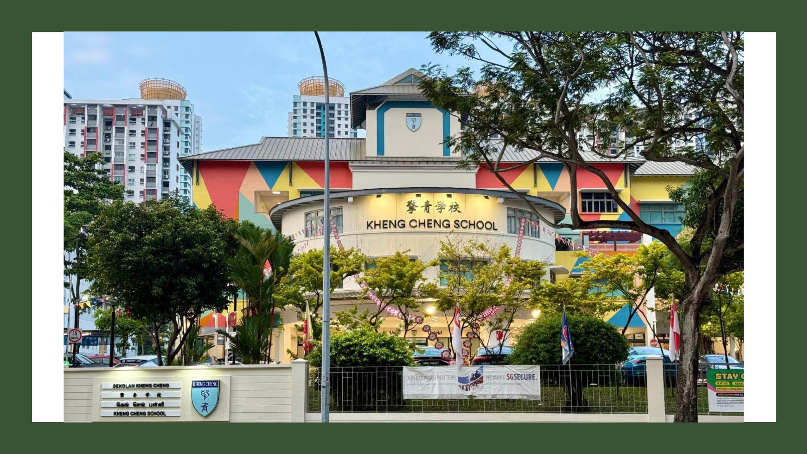 Colorful exterior of Kheng Cheng School in Singapore with bright geometric patterns and surrounding trees.