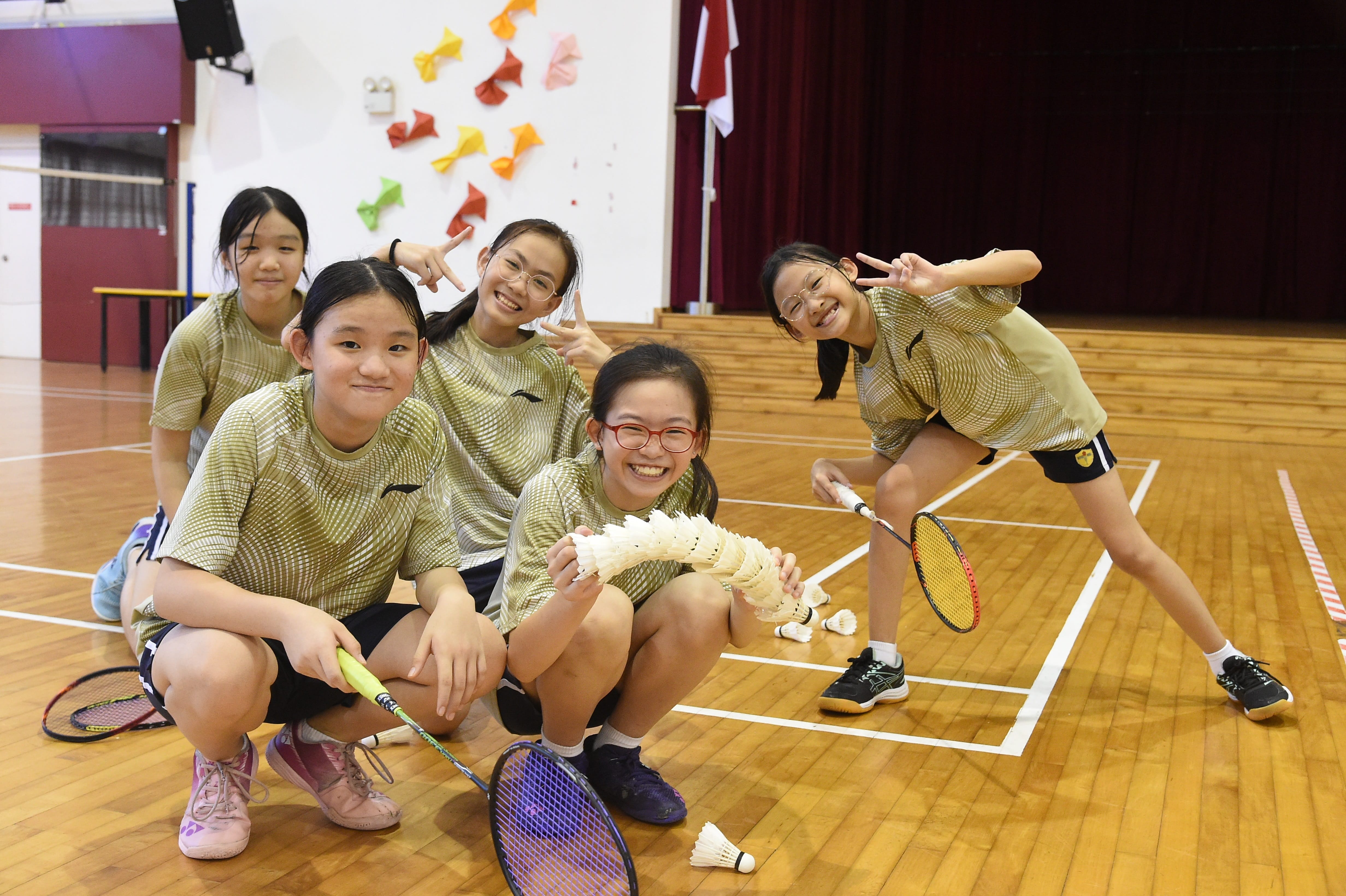 Badminton students posing with their racket and shuttlecock