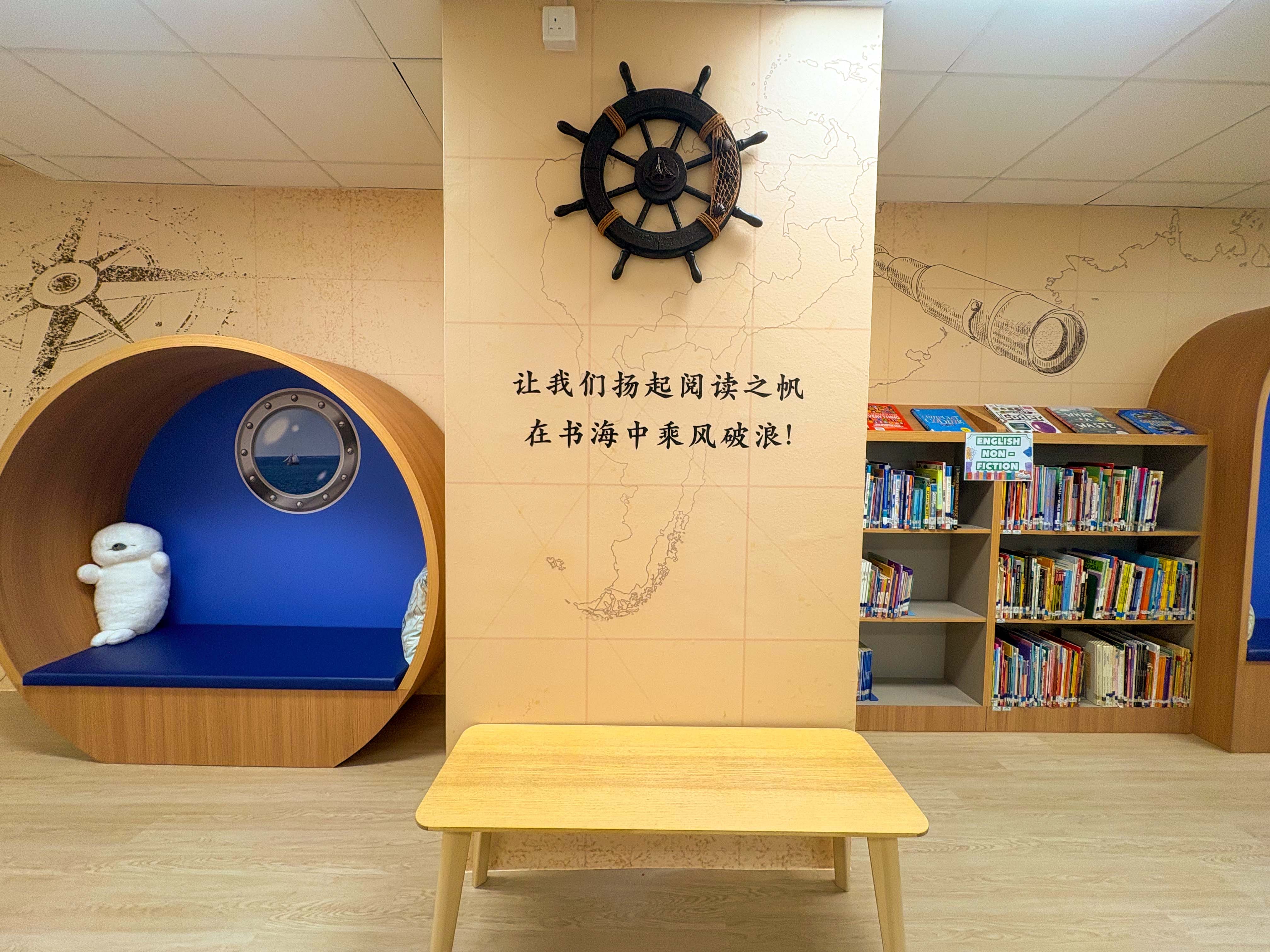 bright school library with a sea exploration theme , showing a cushion corner for reading and wall design