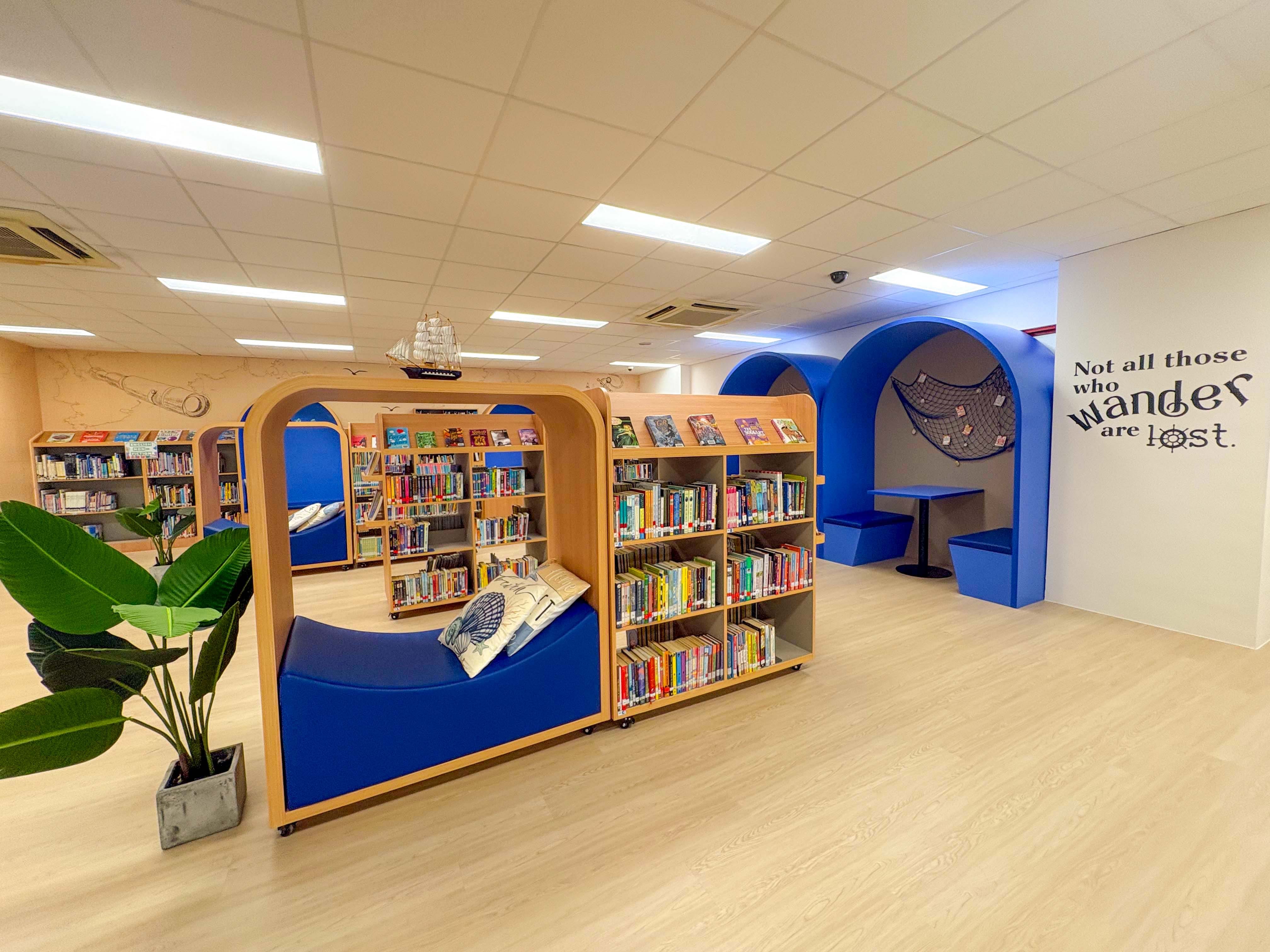 bright school library with a sea exploration theme , showing a cushion corner for reading and quiet working area