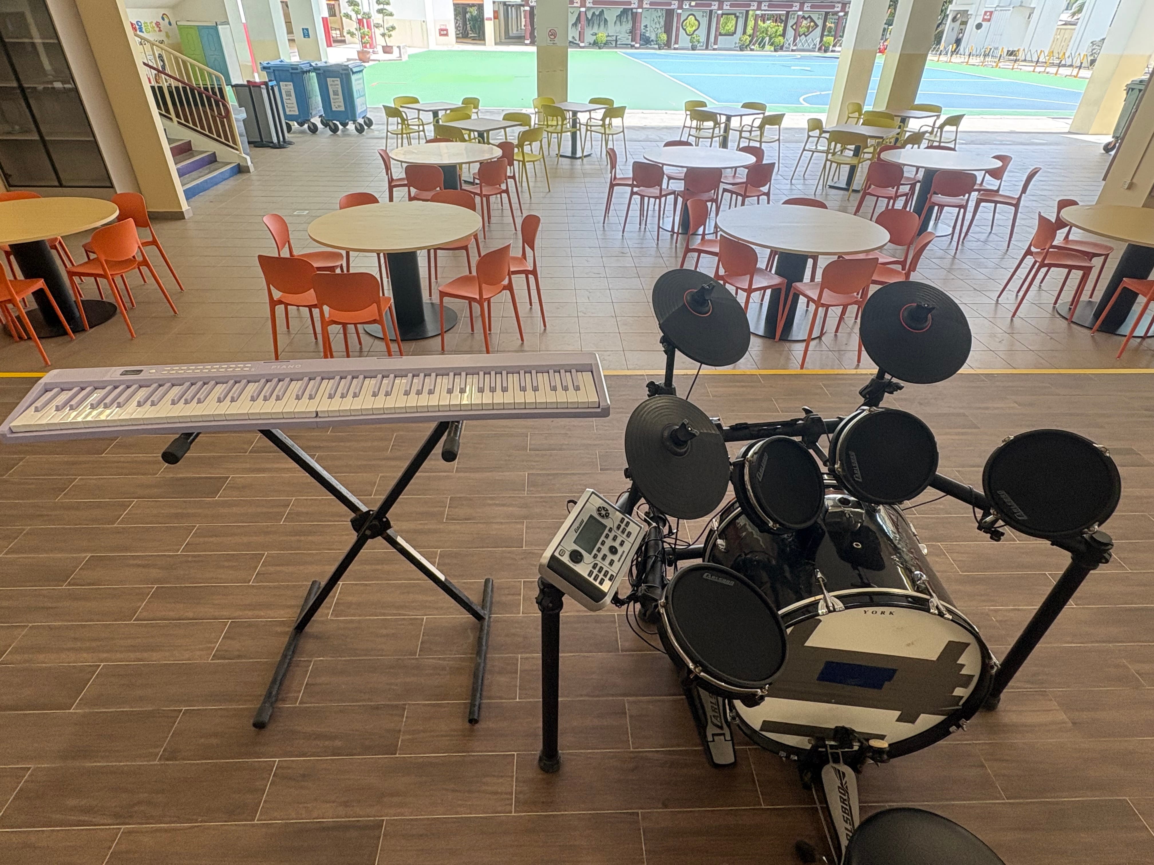 school canteen performance platform with digital piano and drum set