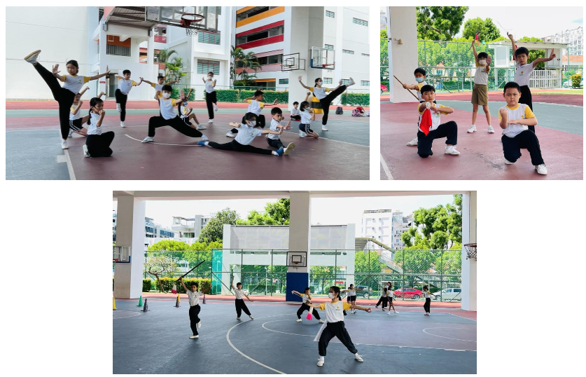 Children in school uniforms practice wushu martial arts poses and staff movements on an outdoor basketball court.