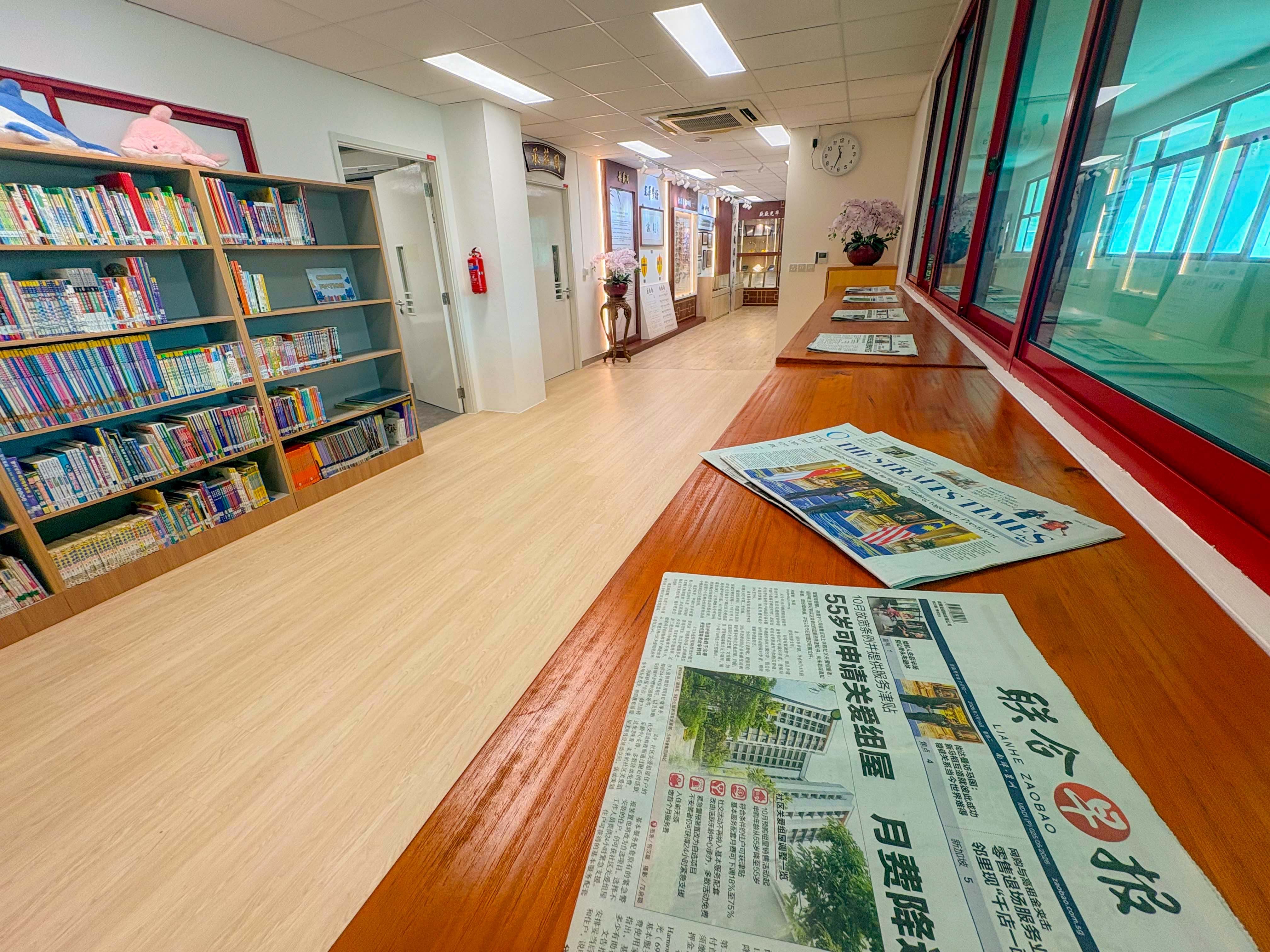 bright school library with a sea exploration theme , Tall tables facing the corridor for newspaper reading