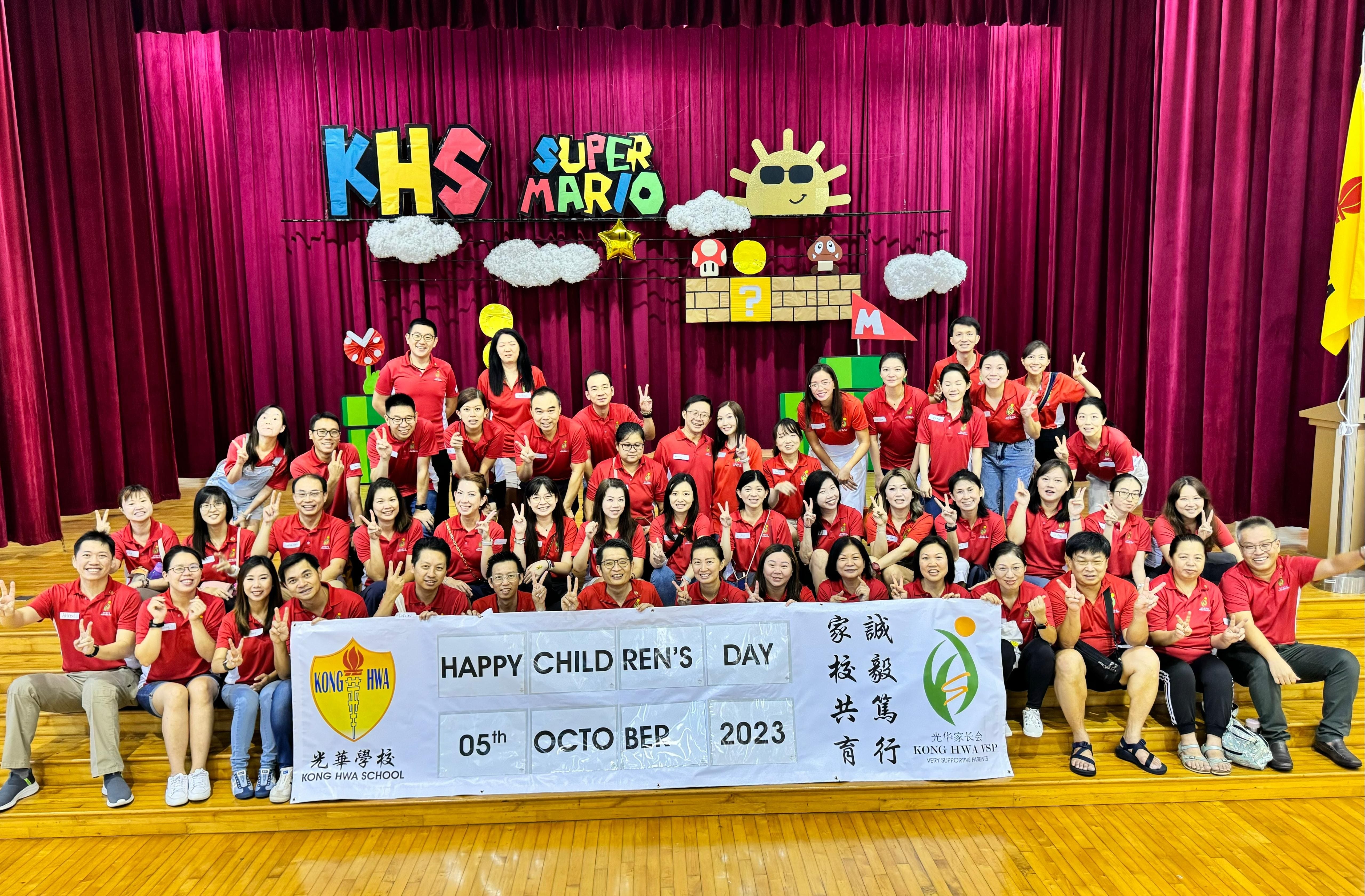 VSP in red shirts posing with a Happy Children's Day banner dated 05 October 2023 at Kong Hwa School.