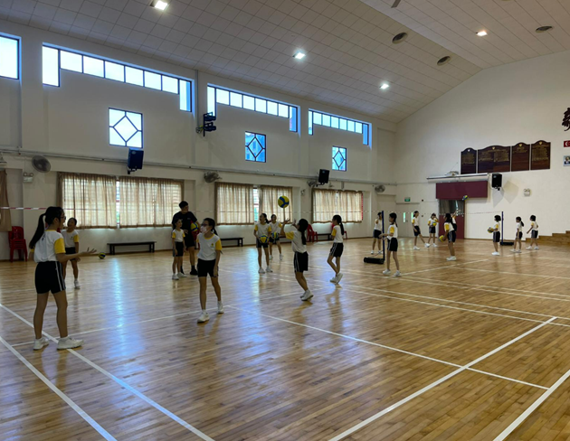 Primary 5 students engaging in a volleyball lesson