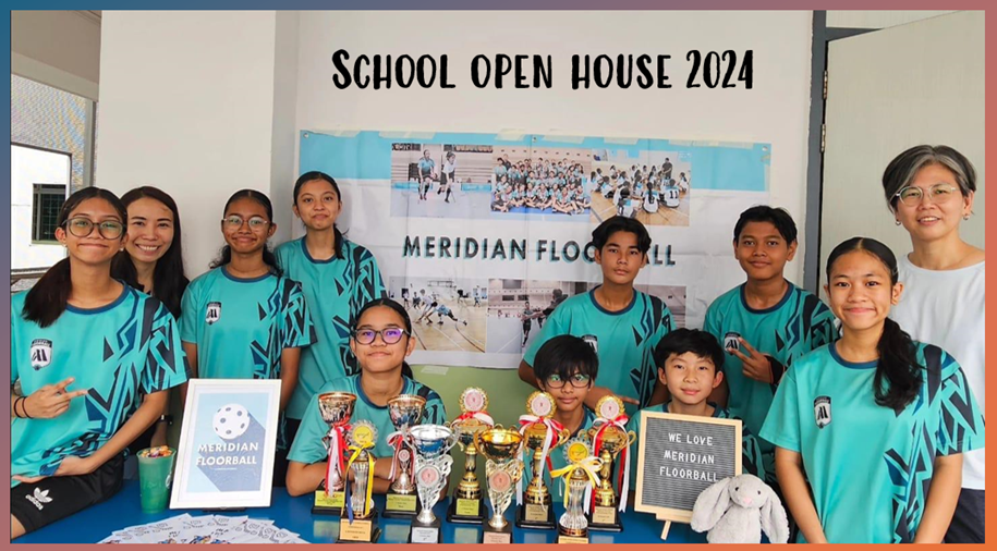 Students in teal Meridian Floorball jerseys pose with trophies at a School Open House 2024 display table.