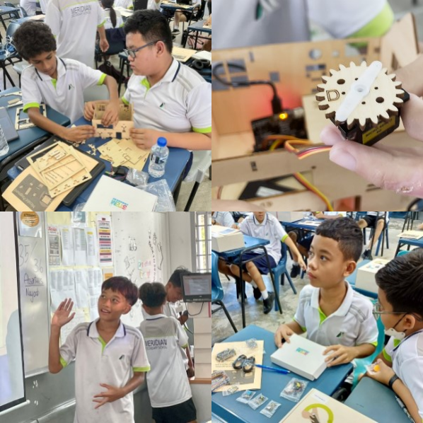 Students in white uniforms work on wooden gear and electronics projects in a classroom setting.